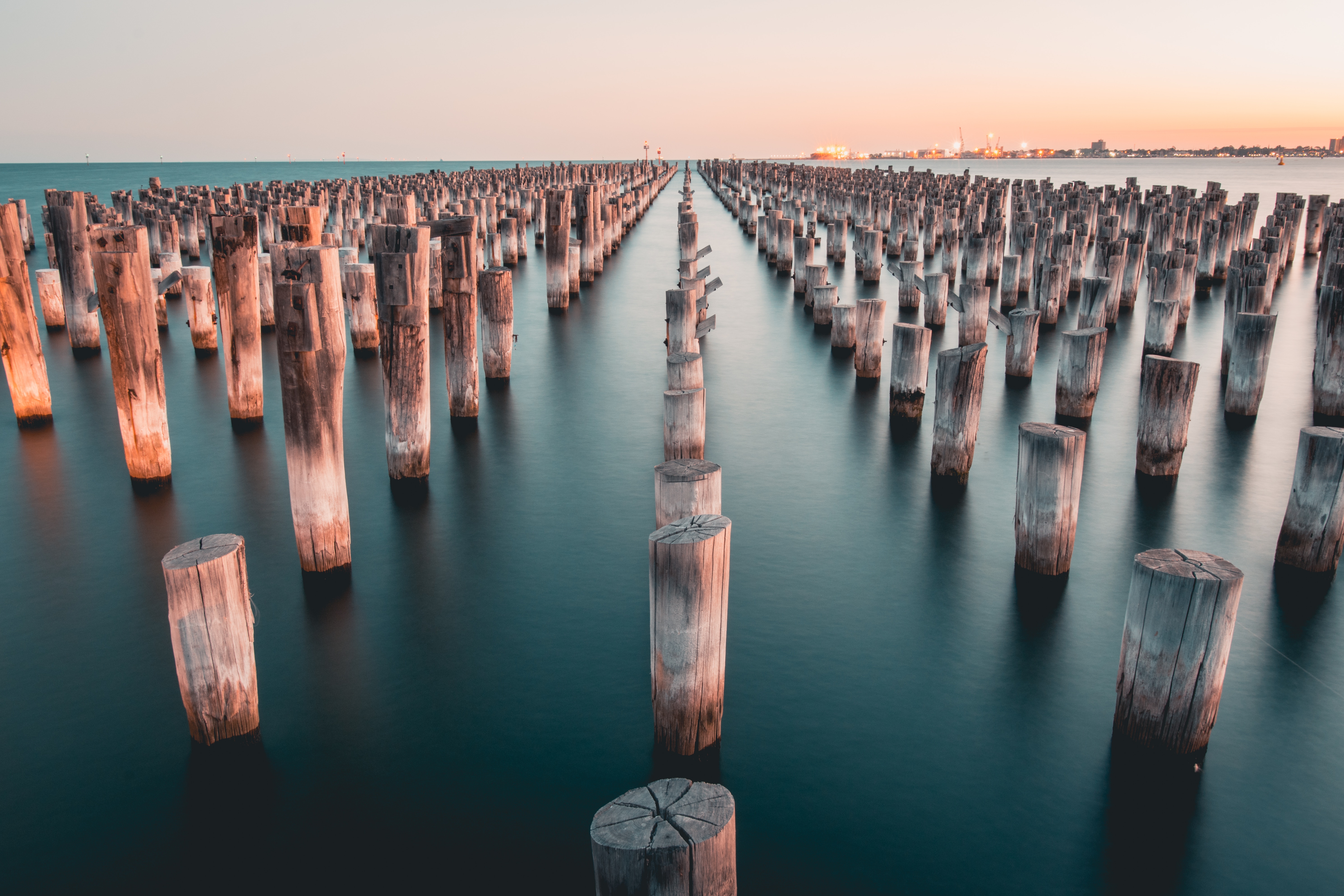 Wooden pilings in the ocean at sunset HD Wallpaper