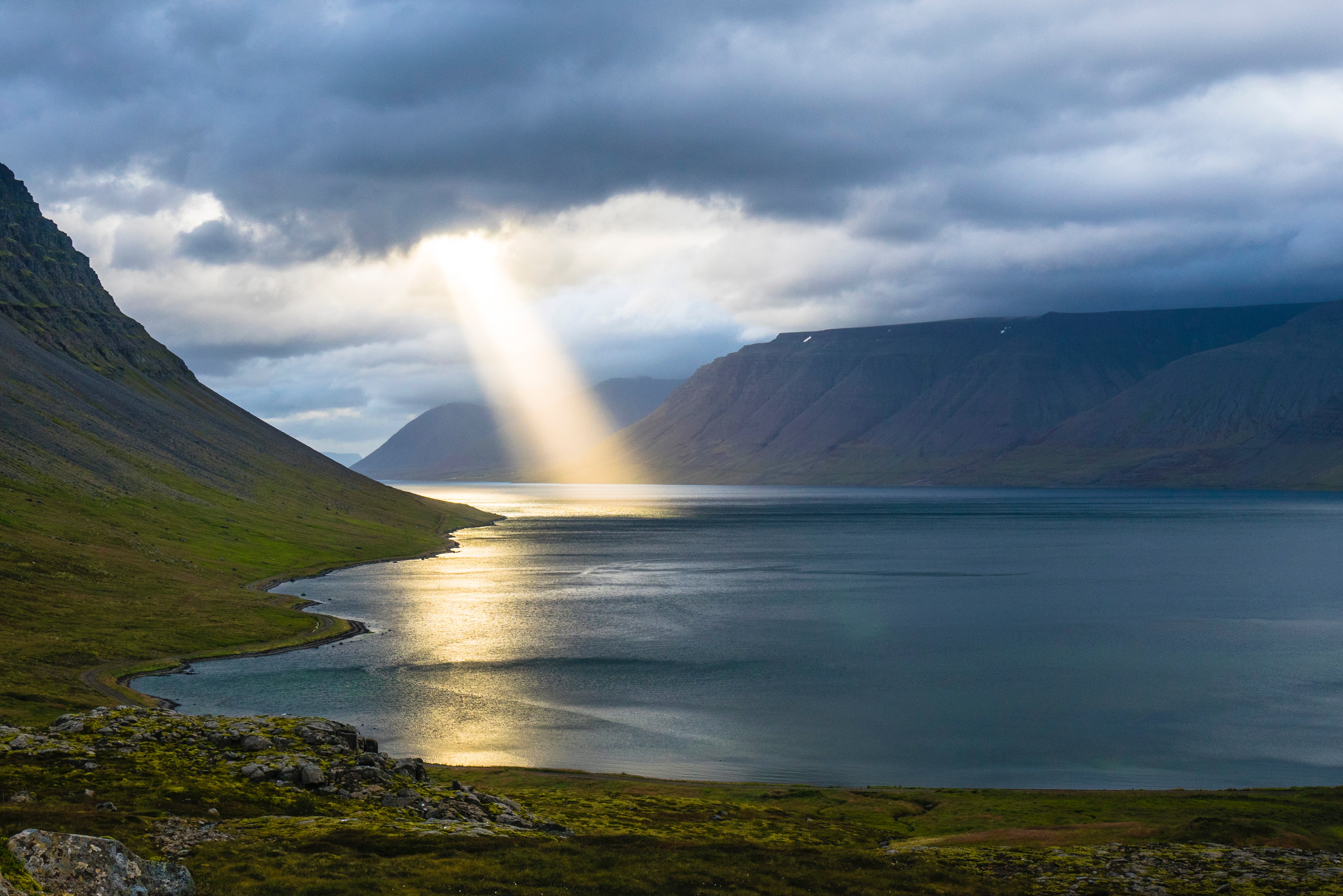 Sunbeam illuminates a fjord with mountains and a lake HD Wallpaper