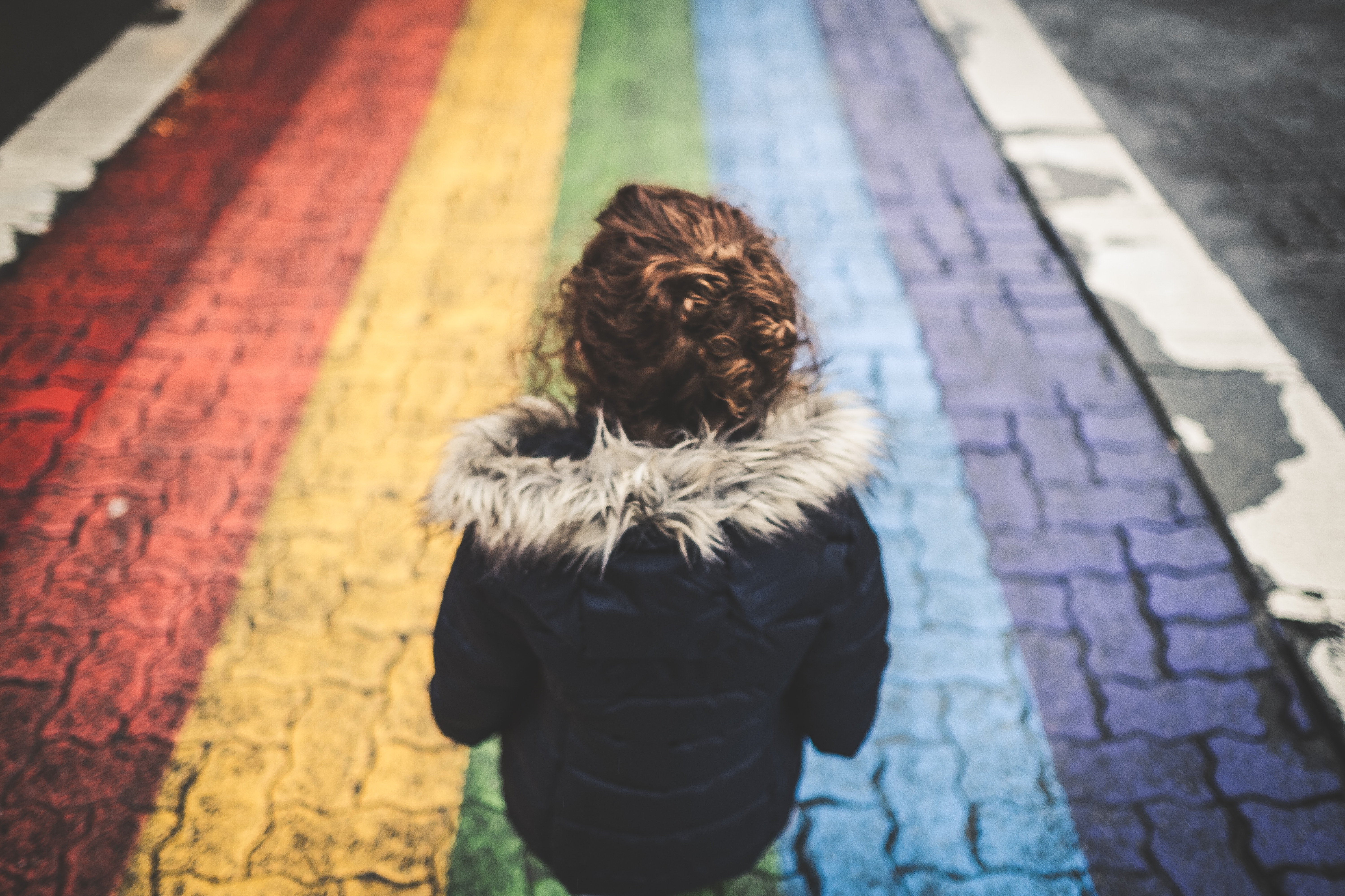 Child walking on a rainbow crosswalk HD Wallpaper