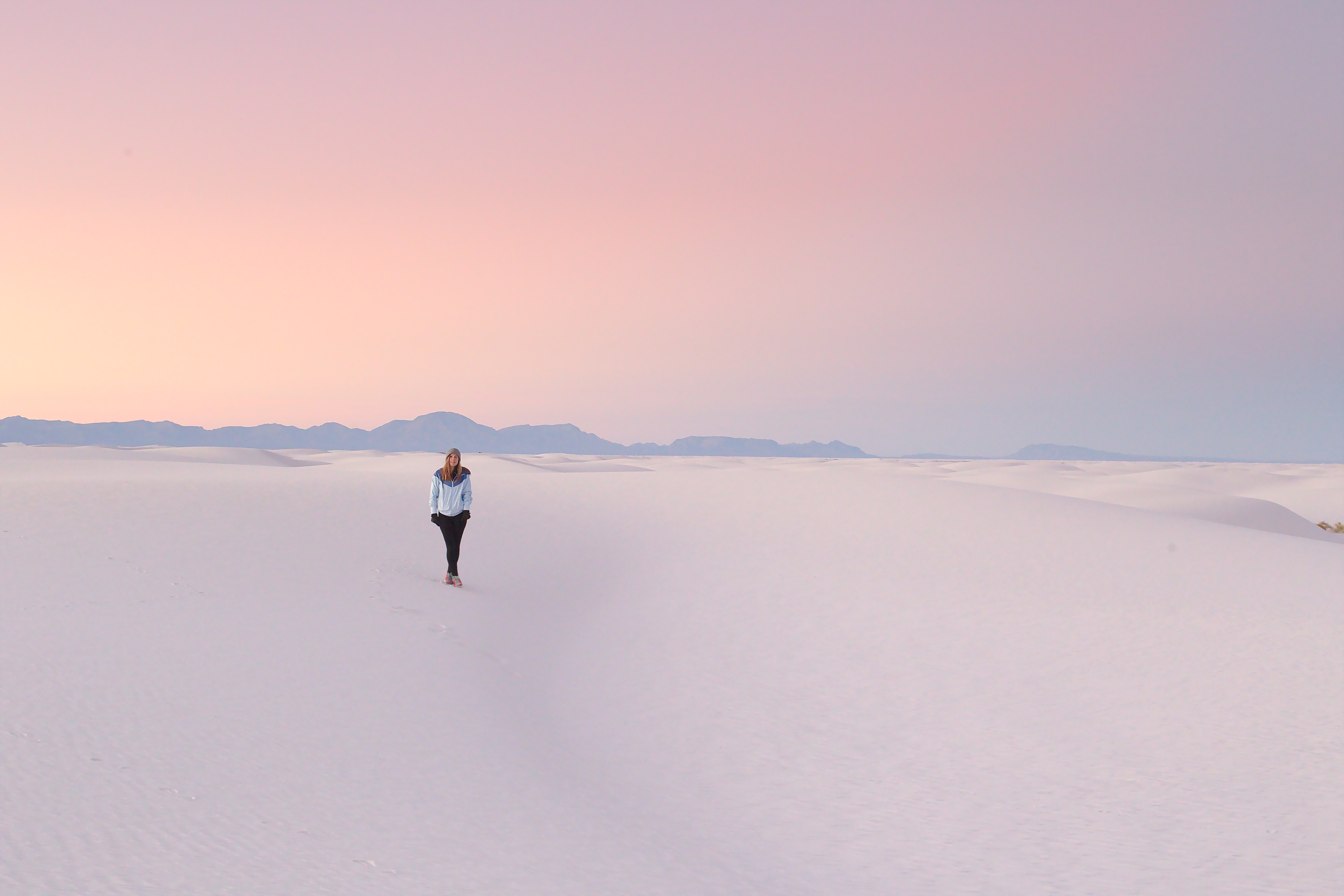 Woman walking in white sand dunes at sunset HD Wallpaper