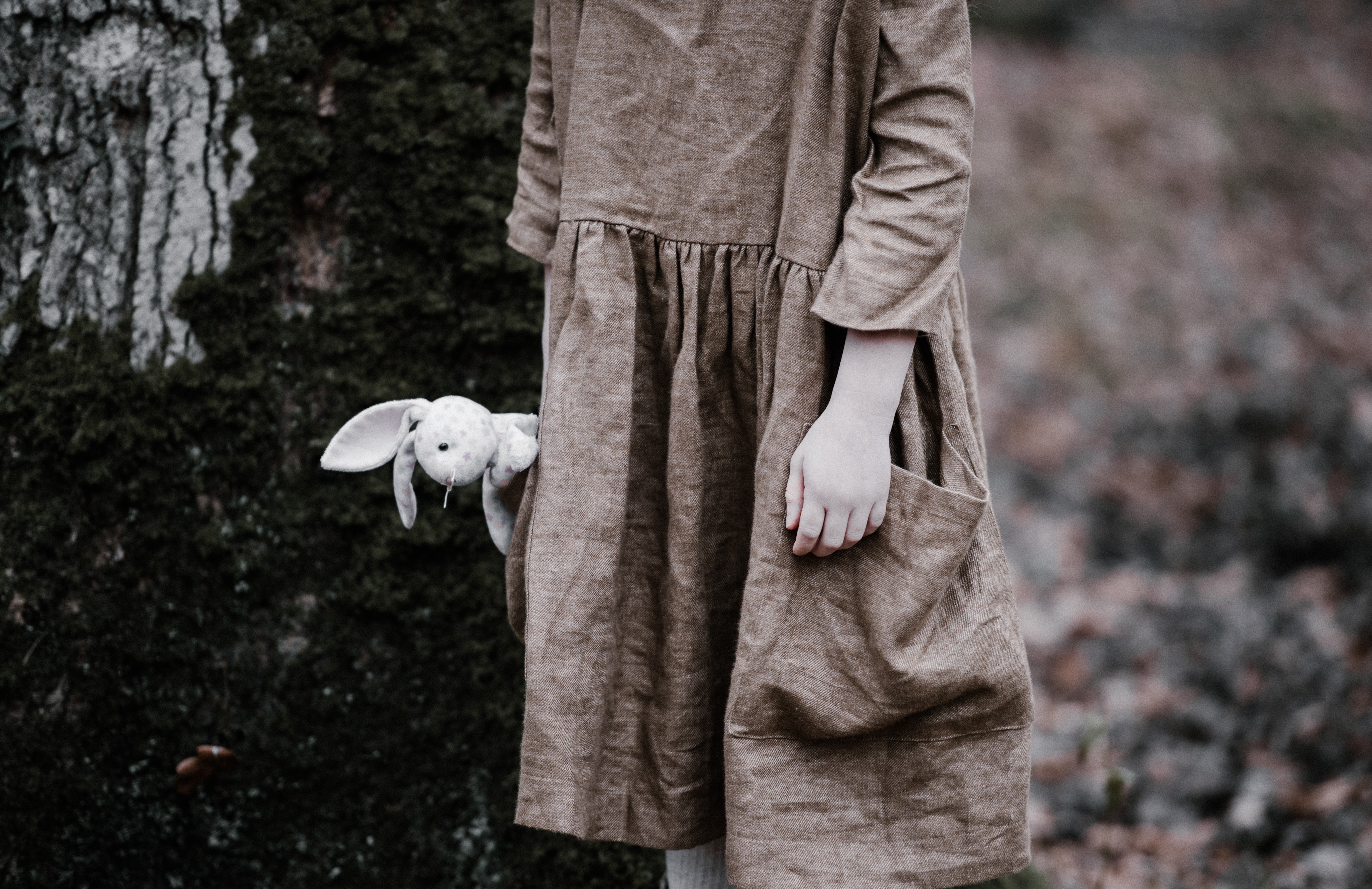 Girl holding a bunny toy in a forest HD Wallpaper