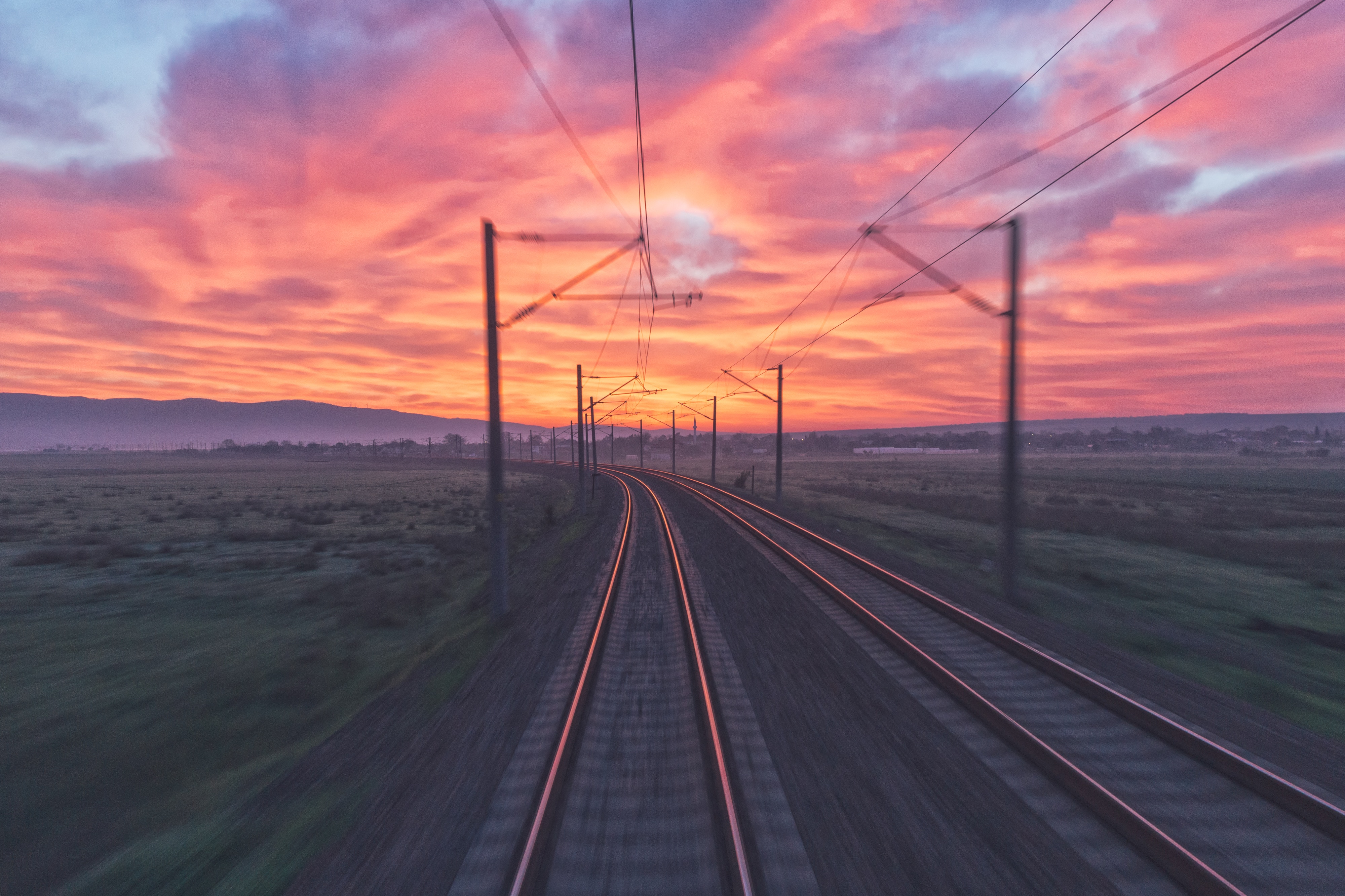 Train tracks at sunset with pink and orange clouds HD Wallpaper