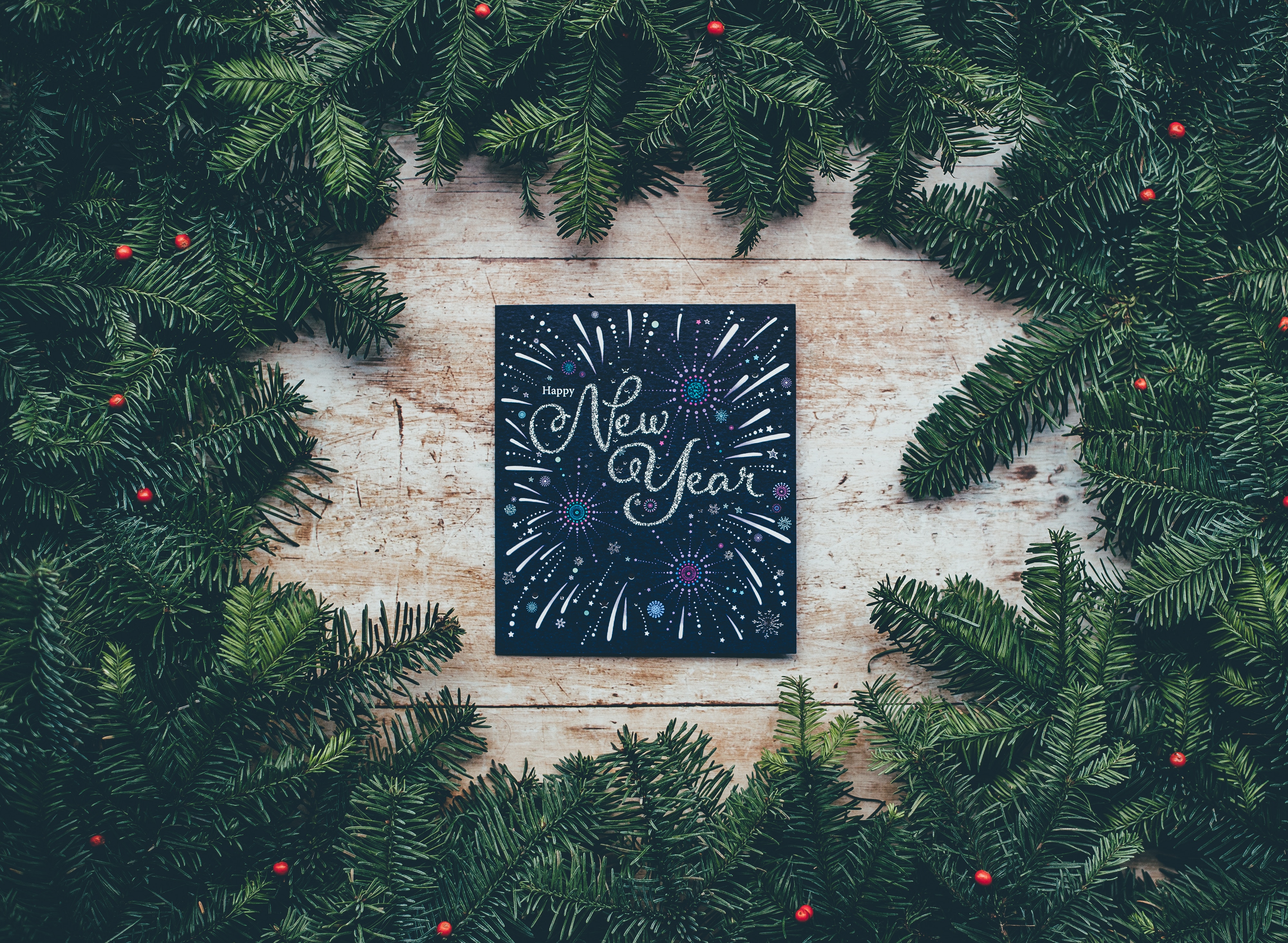 Happy New Year card surrounded by evergreen branches HD Wallpaper
