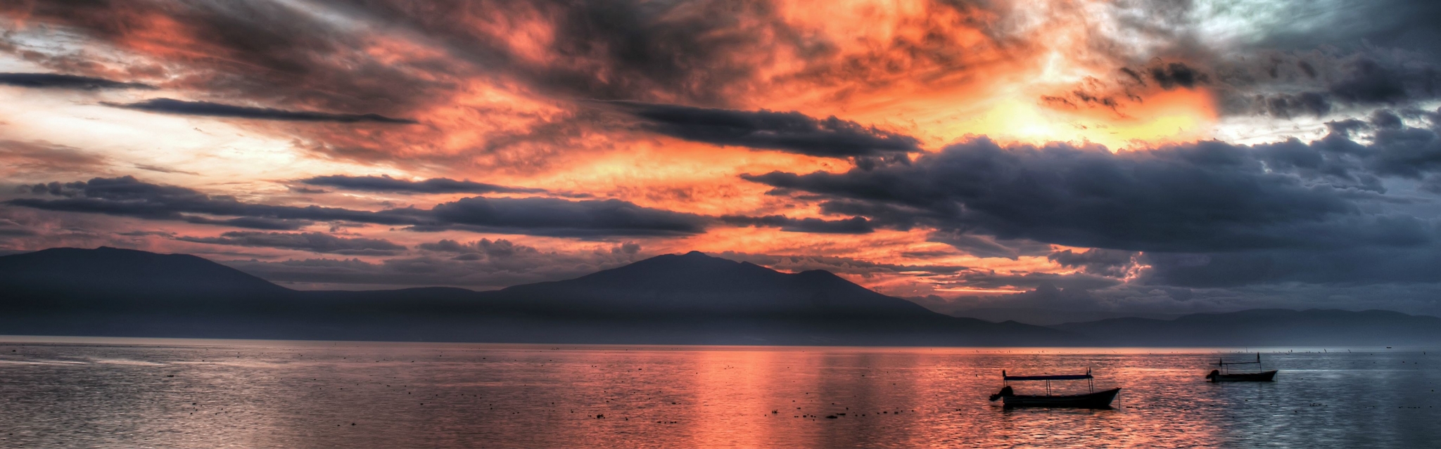 Panoramic sunset over a calm lake with boats HD Wallpaper