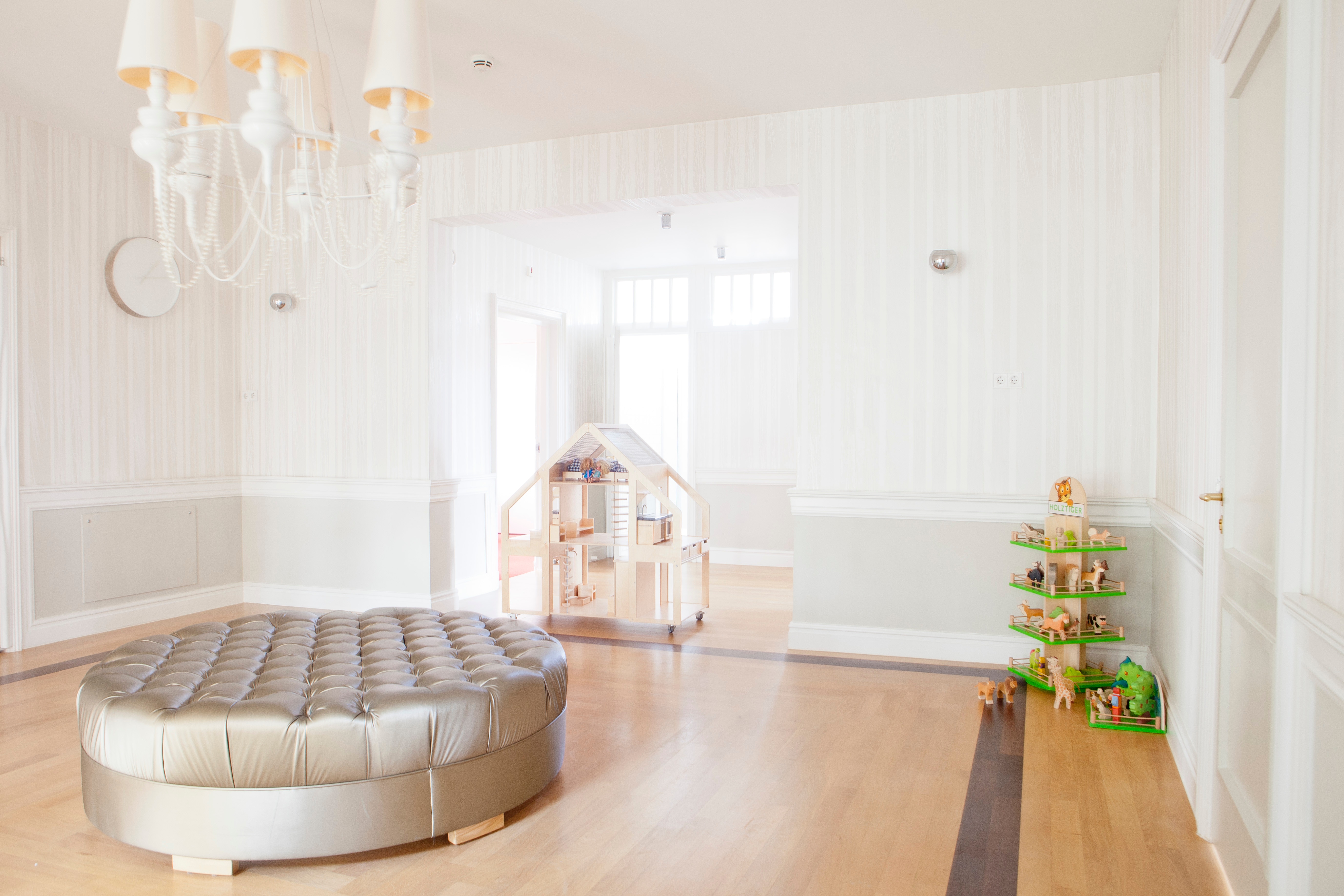 Bright interior with ottoman, dollhouse, and toy farm HD Wallpaper