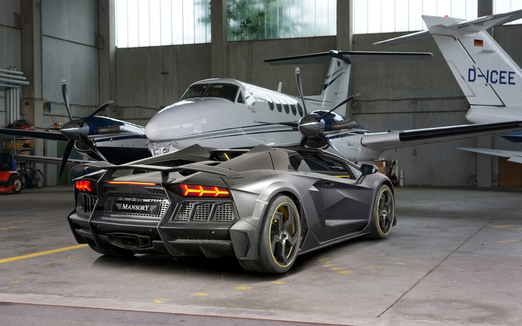 Mansory Lamborghini Aventador parked in hangar with private jets HD Wallpaper