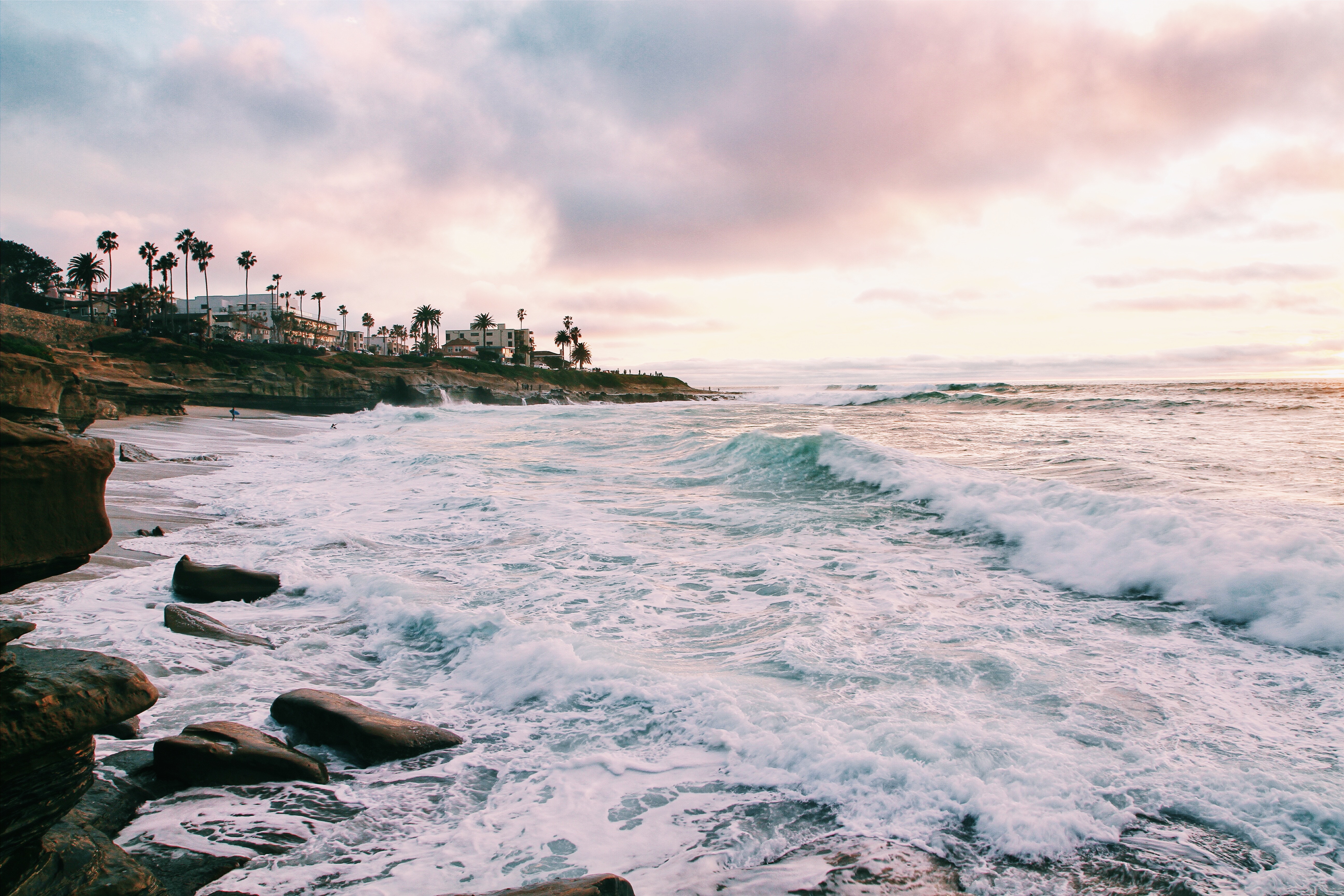 Waves crash on a rocky beach in San Diego at sunset HD Wallpaper