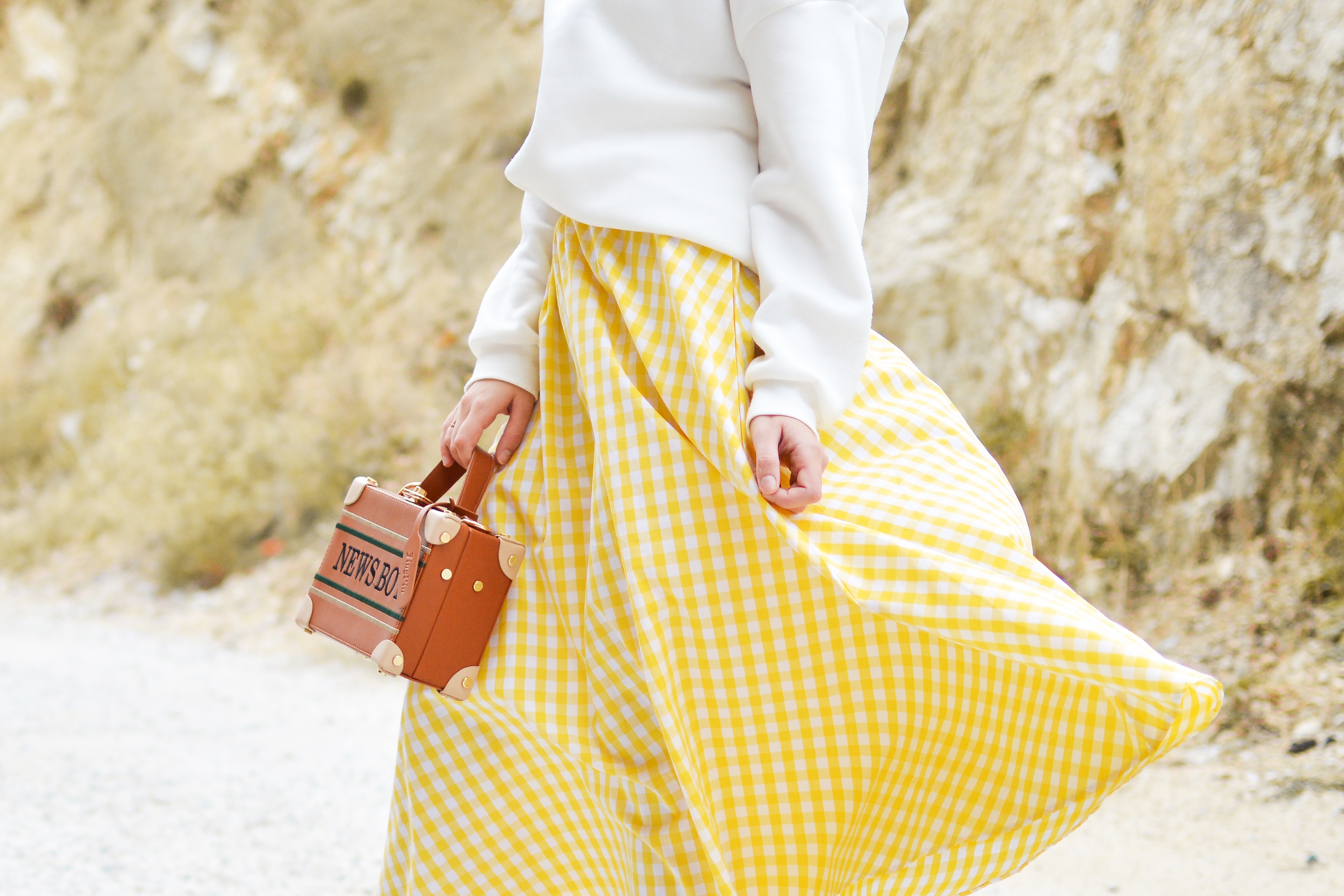 Woman in yellow gingham skirt holding a suitcase HD Wallpaper