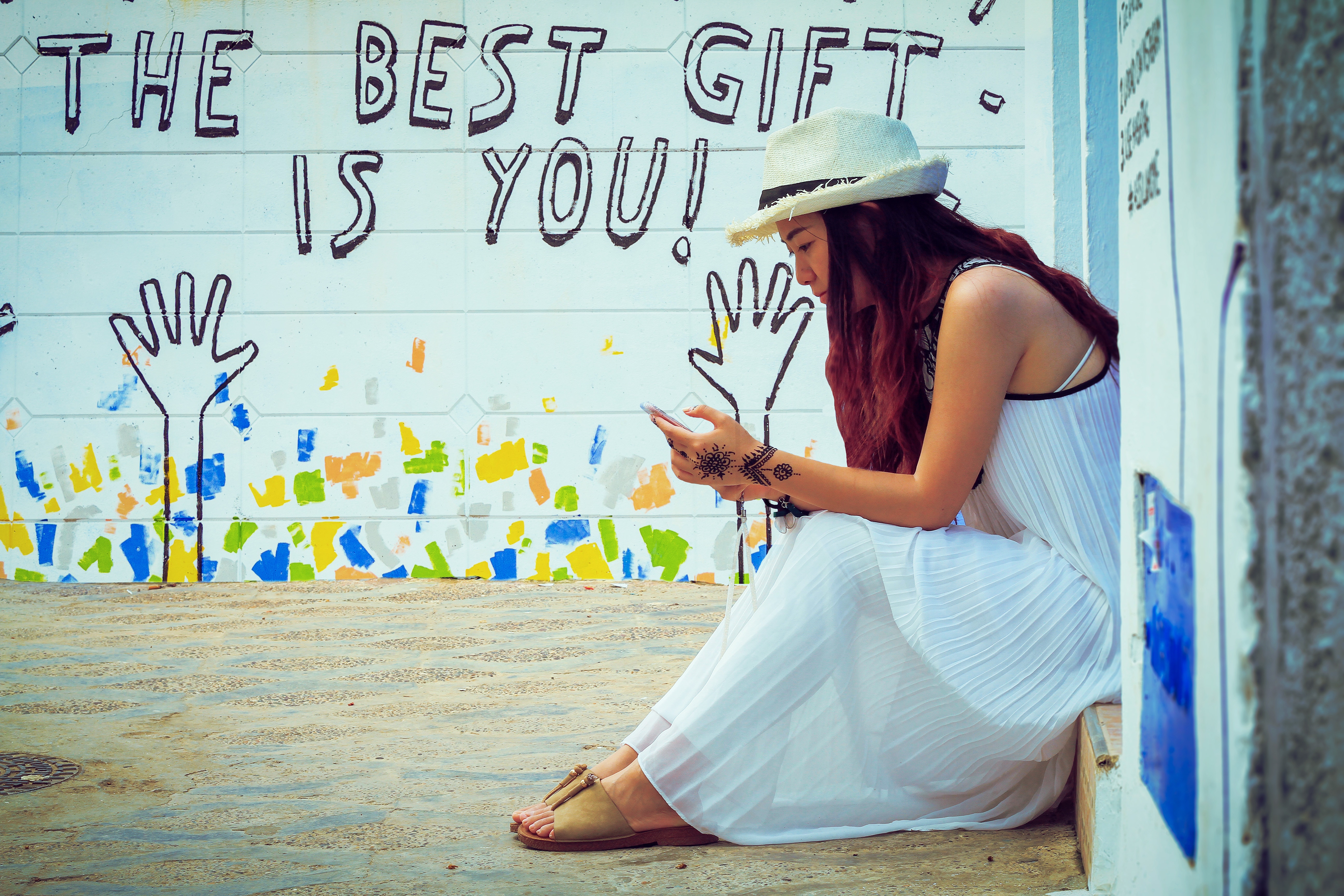 Woman in white dress and hat looking at phone HD Wallpaper