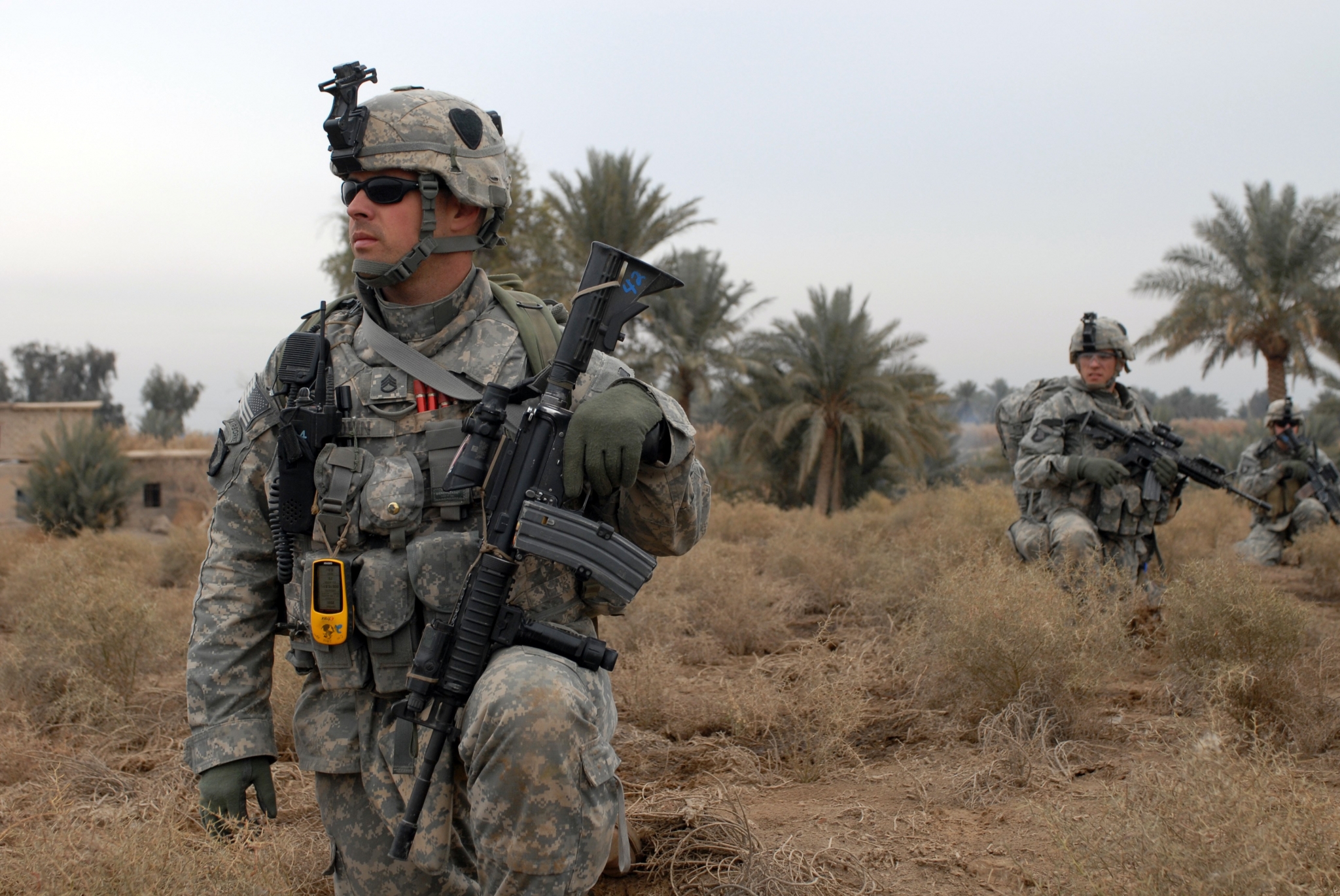 Soldiers in desert landscape with palm trees HD Wallpaper