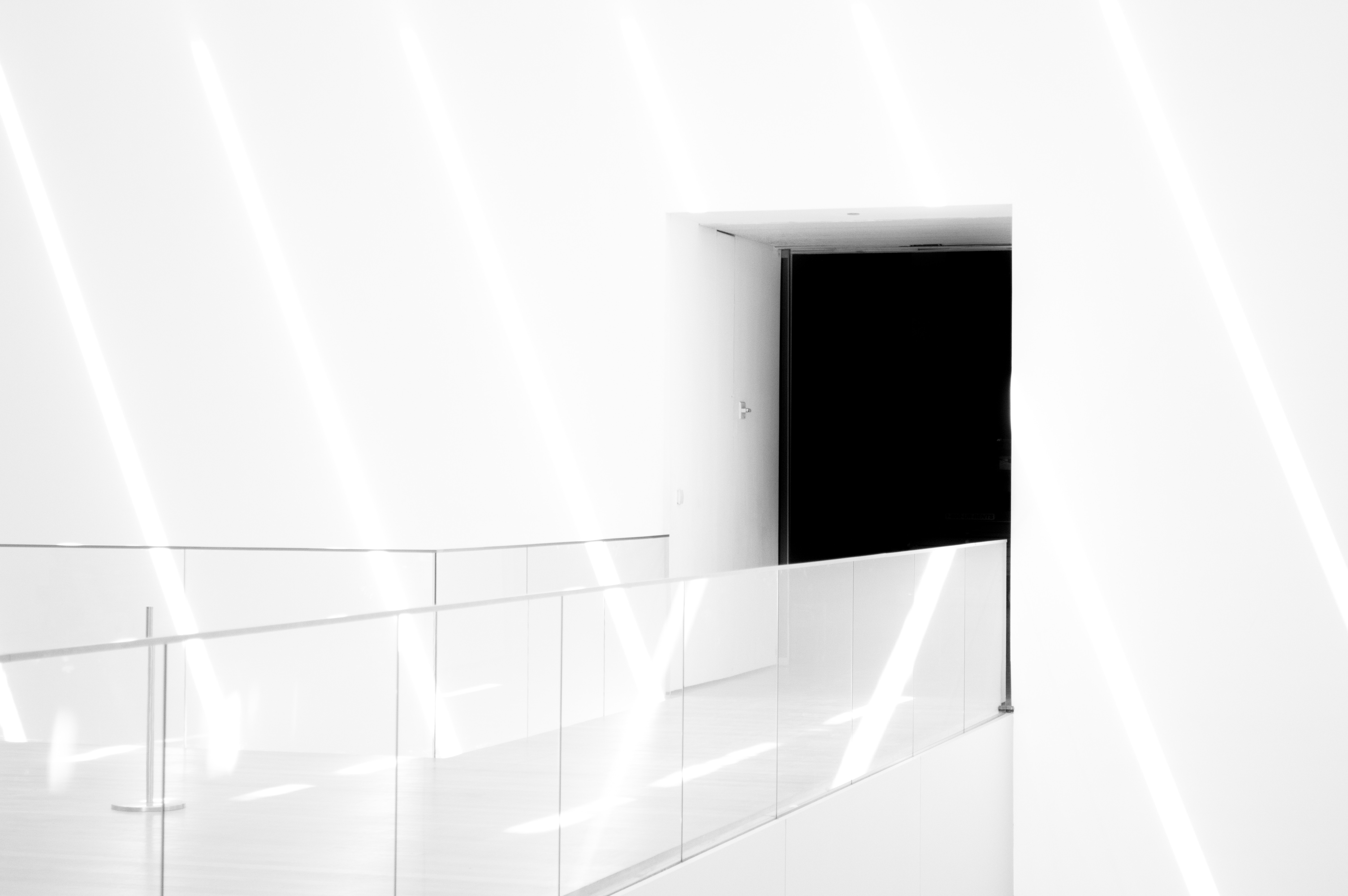 Minimalist hallway with light beams and a dark doorway HD Wallpaper