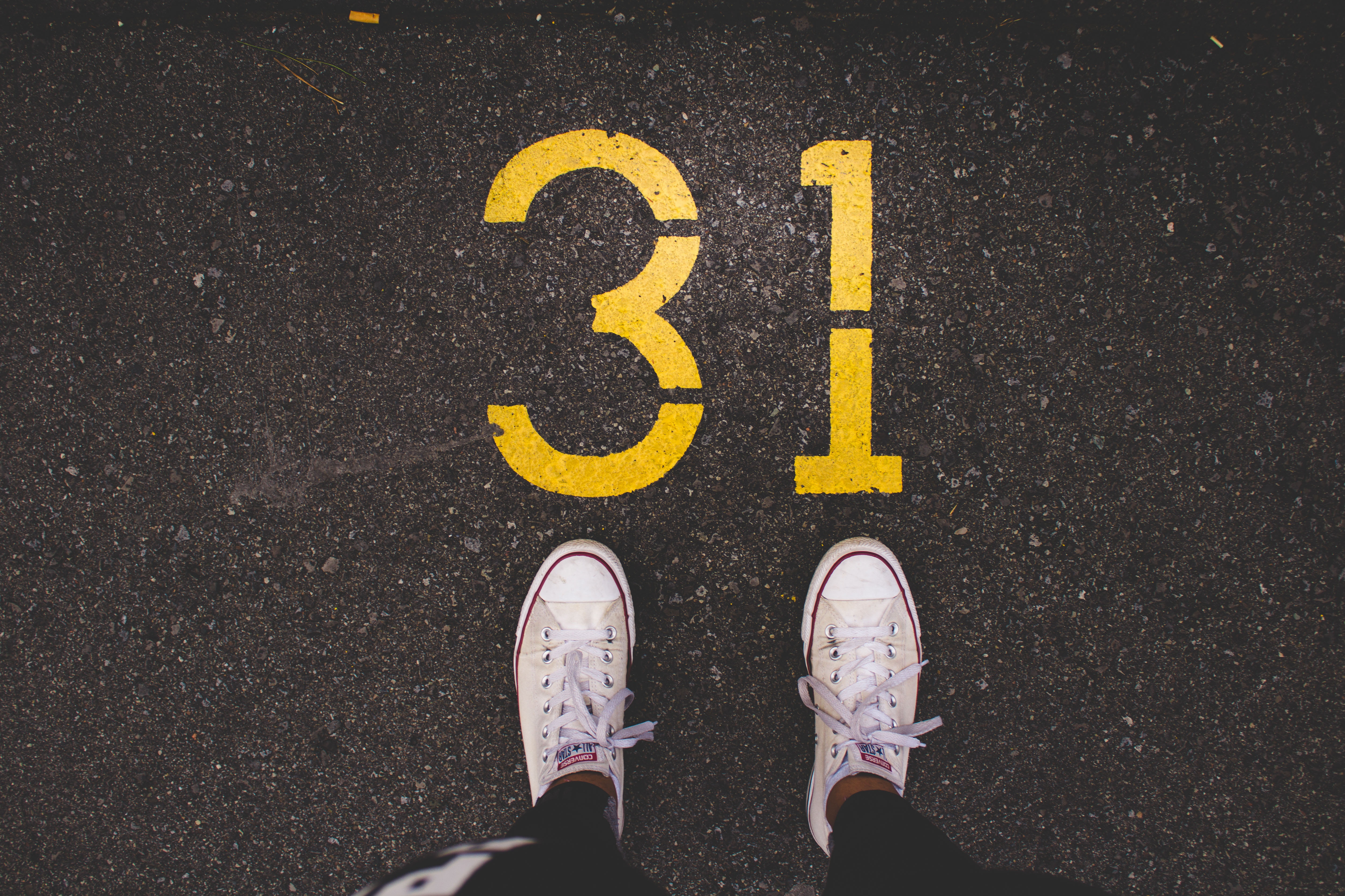 Person standing on asphalt with number 31 painted HD Wallpaper