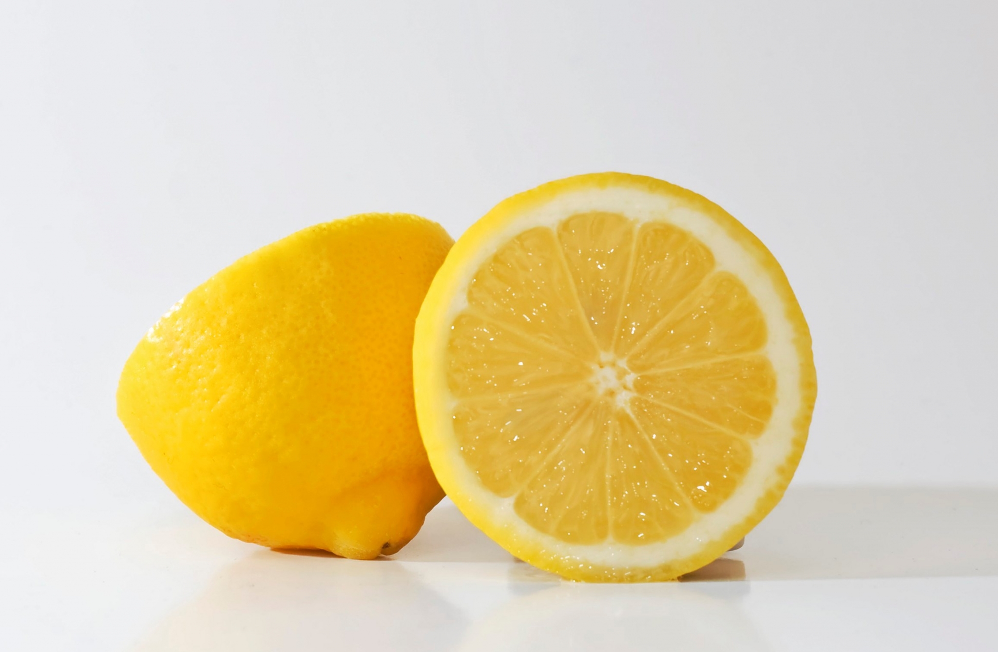 Two lemons, one whole and one sliced HD Wallpaper