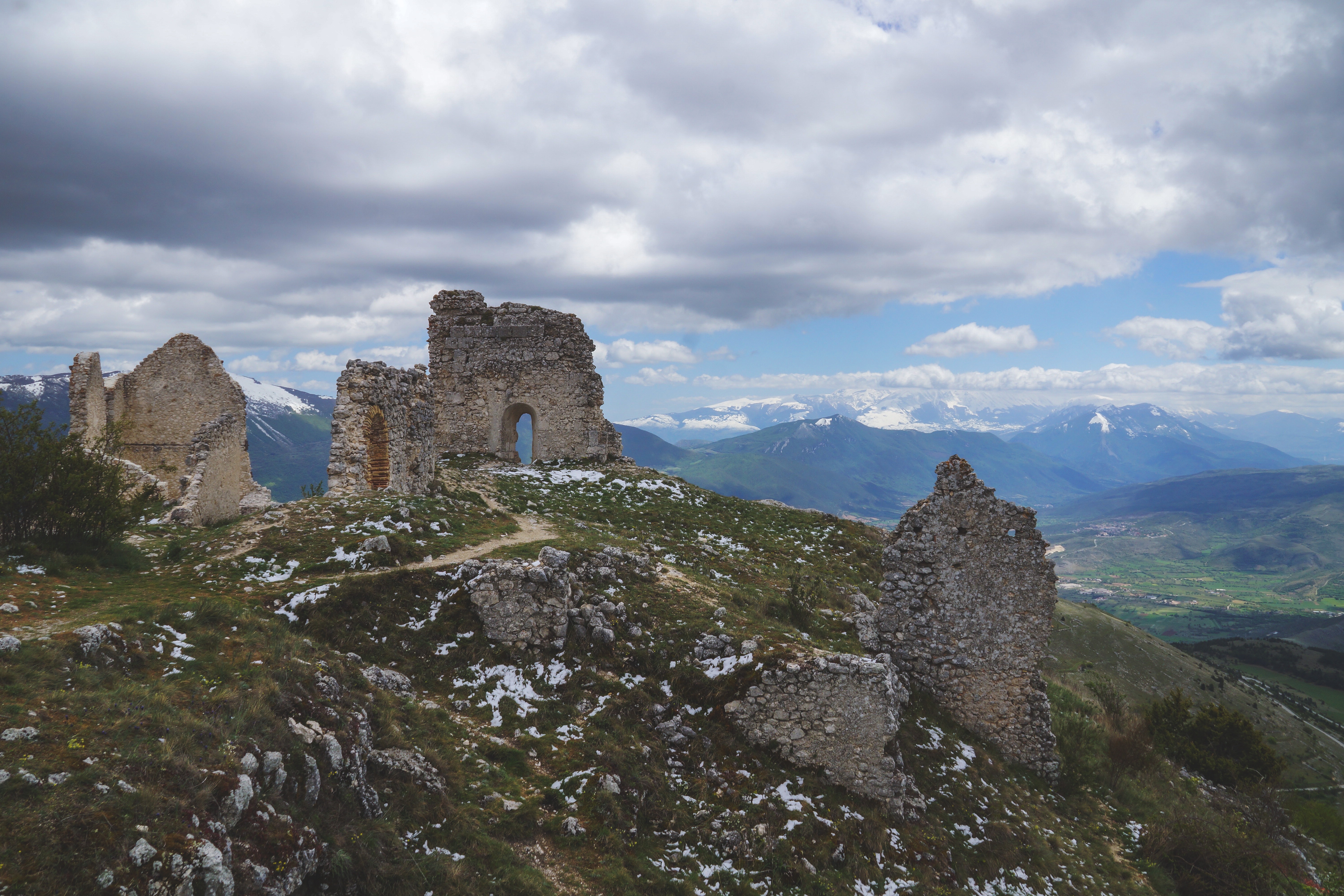 Ruins of a stone castle on a mountain under an overcast sky HD Wallpaper
