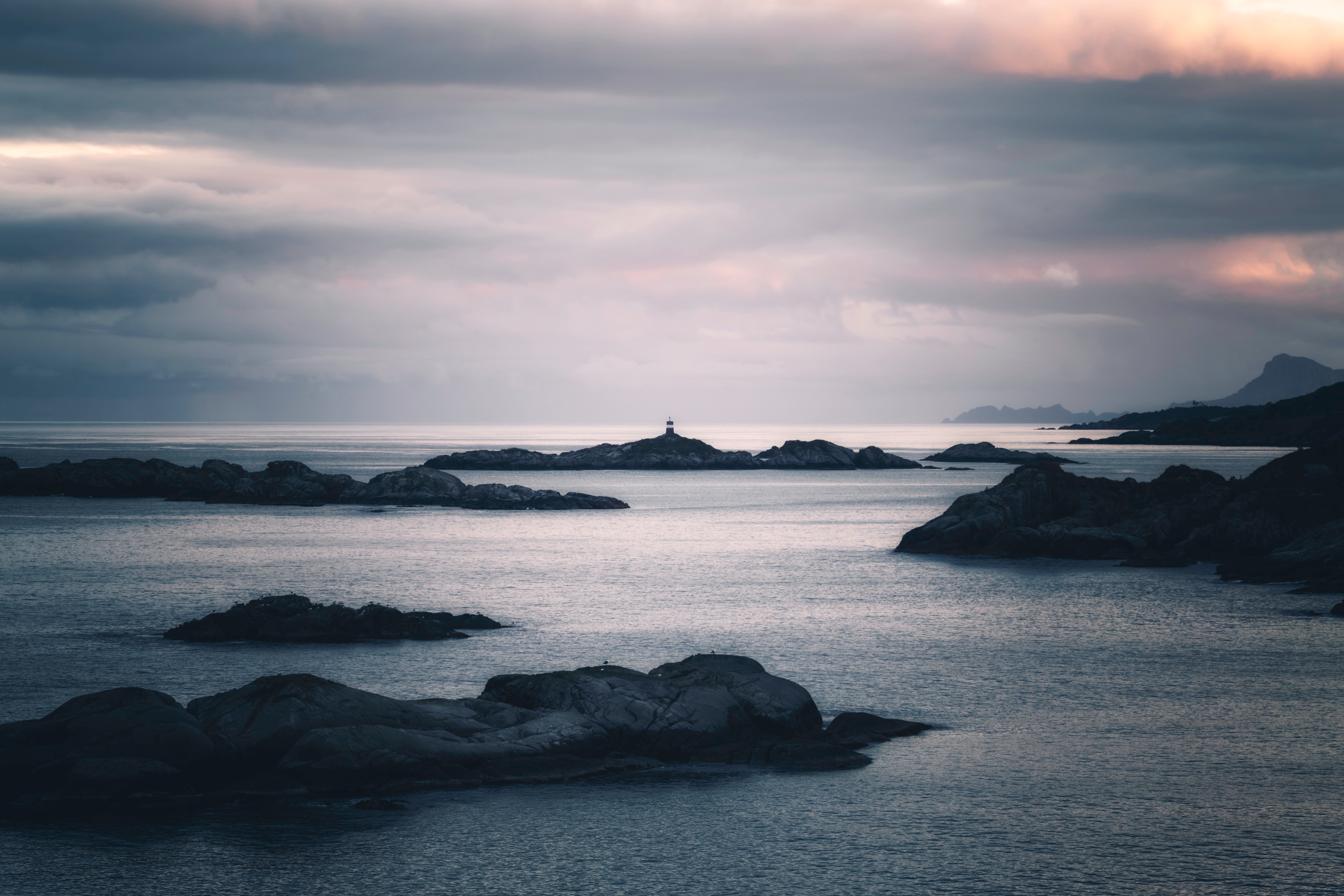 Lighthouse on an island in the ocean at sunset HD Wallpaper