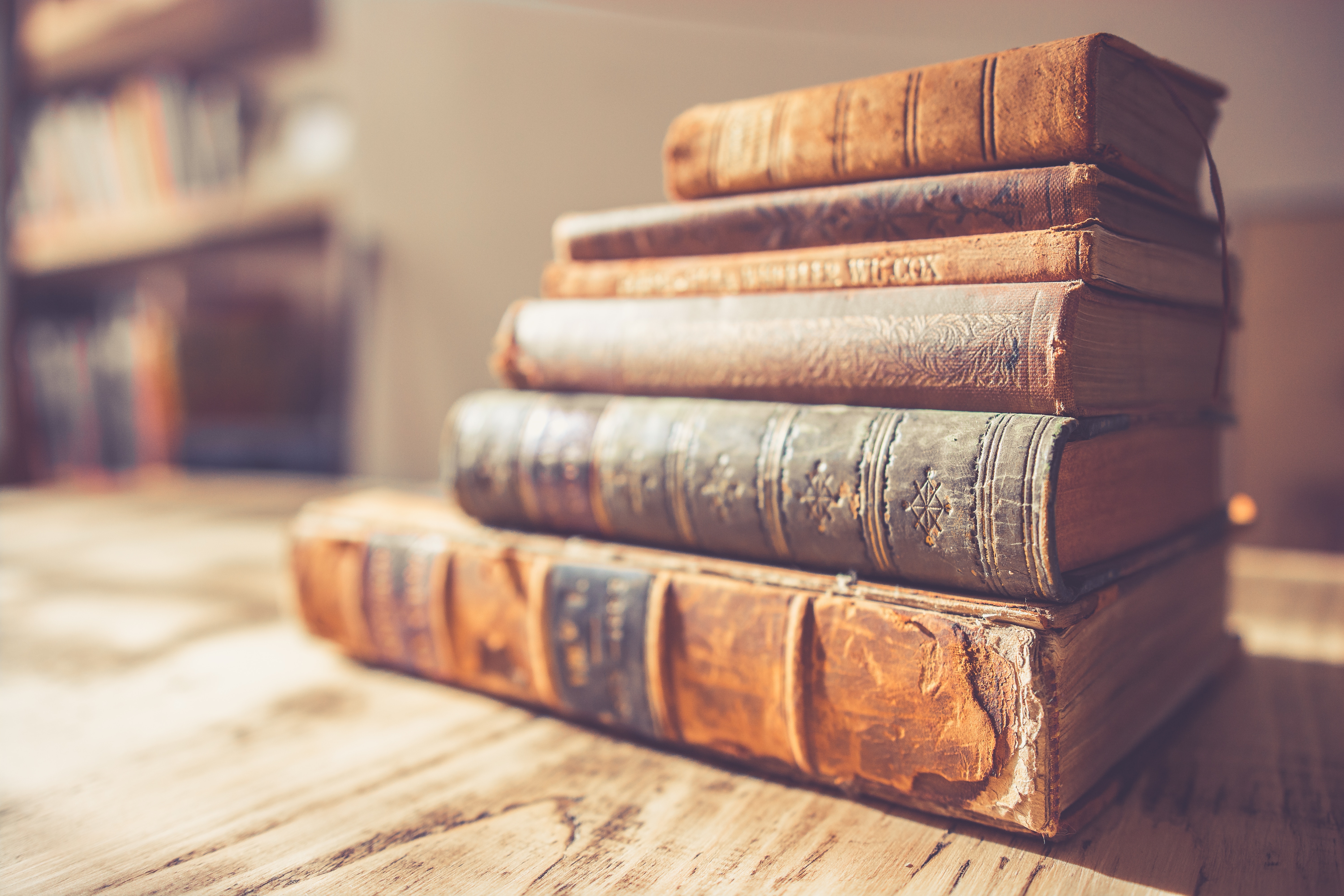 Stack of old vintage hardcover books on a wooden table HD Wallpaper