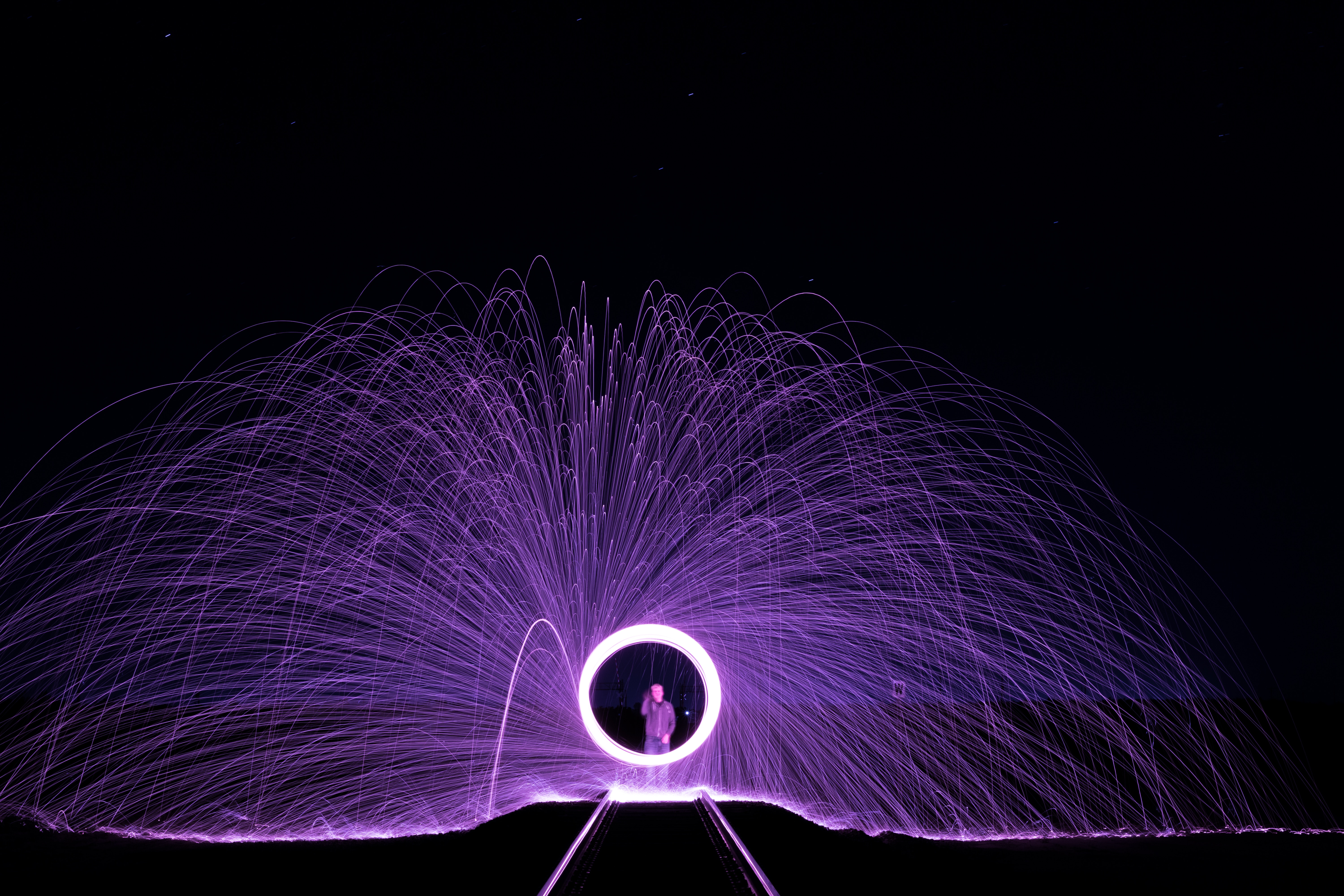 Man in a circle of purple light painting with fire HD Wallpaper