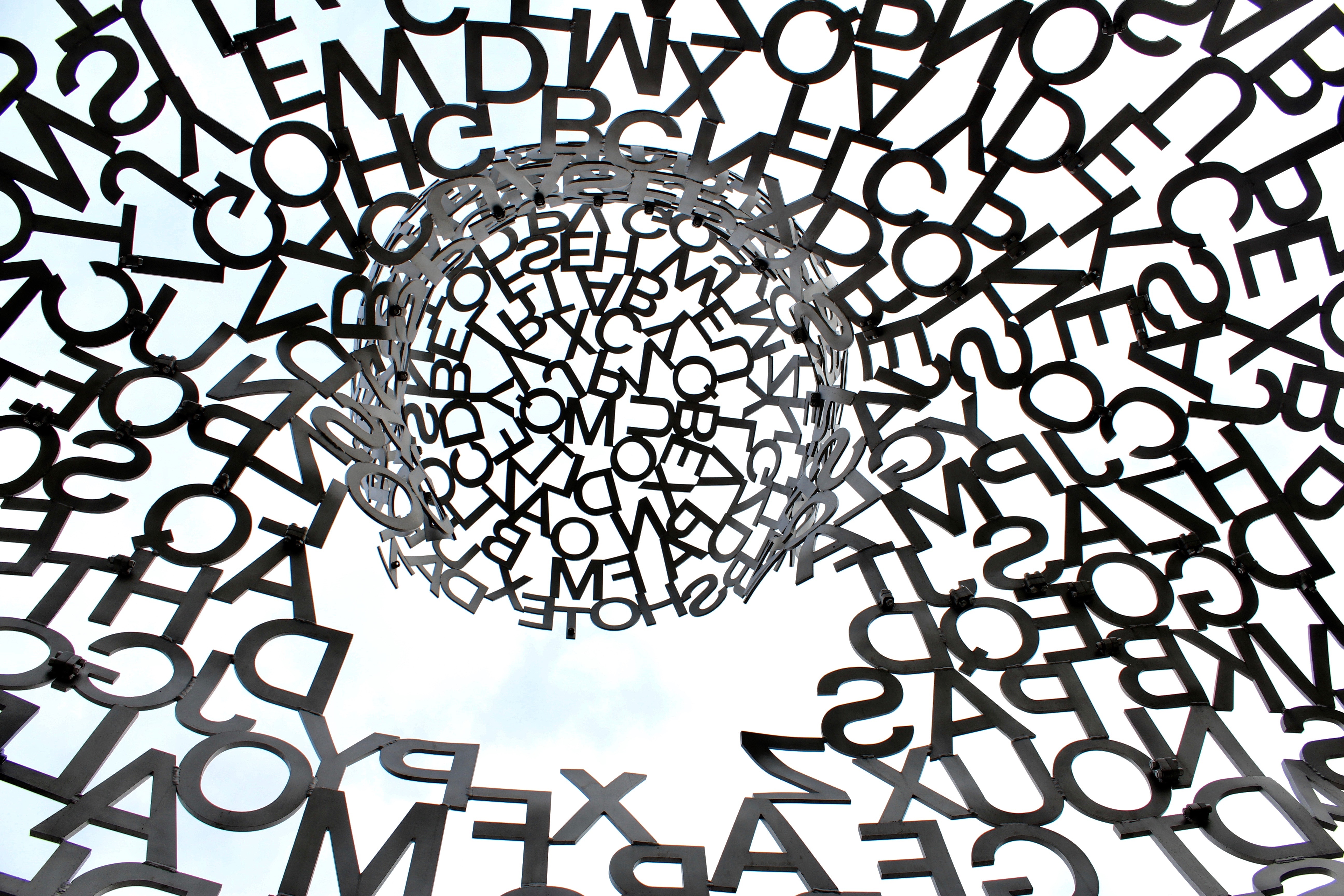 Abstract sculpture of letters against the sky HD Wallpaper