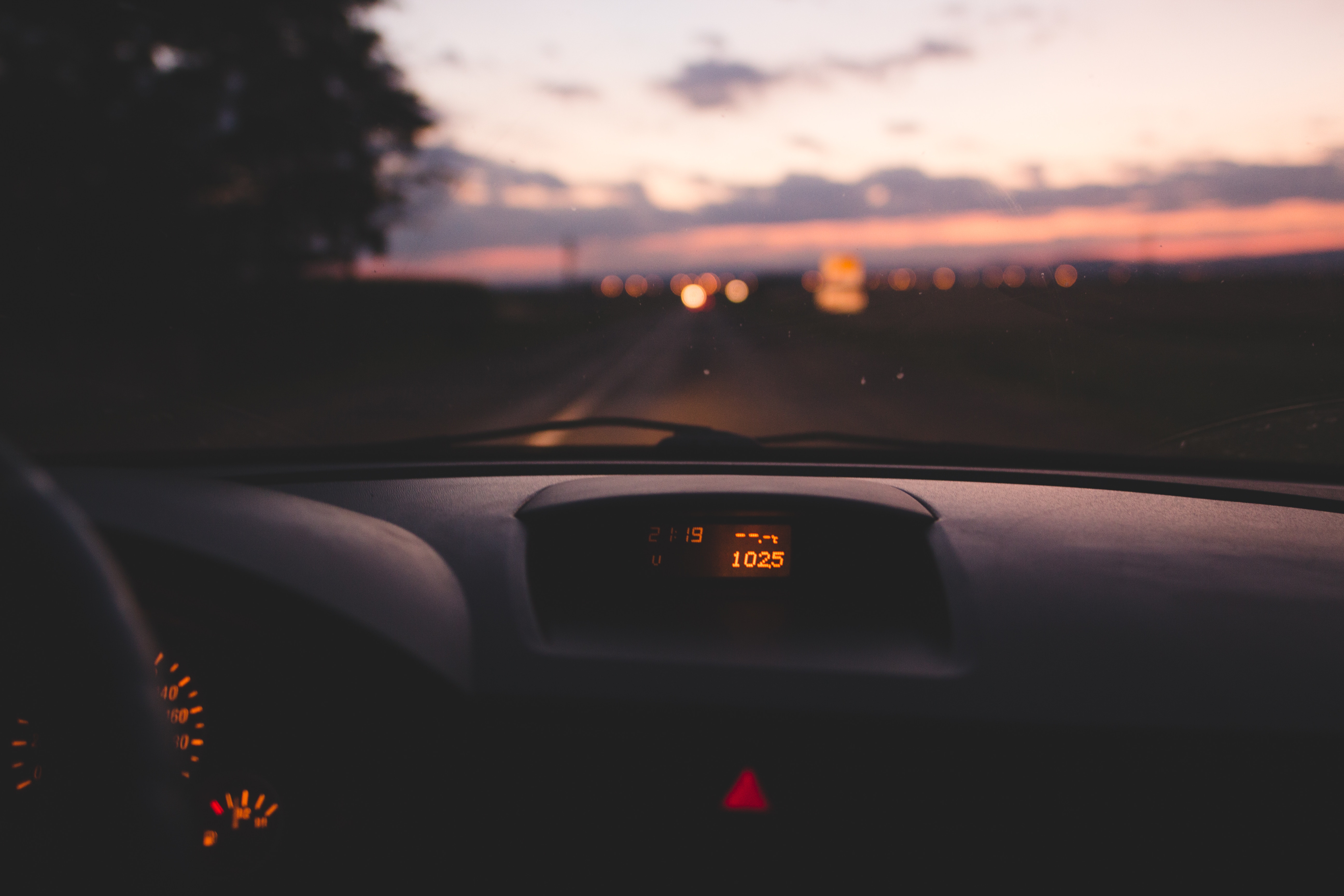 Car dashboard at sunset with bokeh lights HD Wallpaper