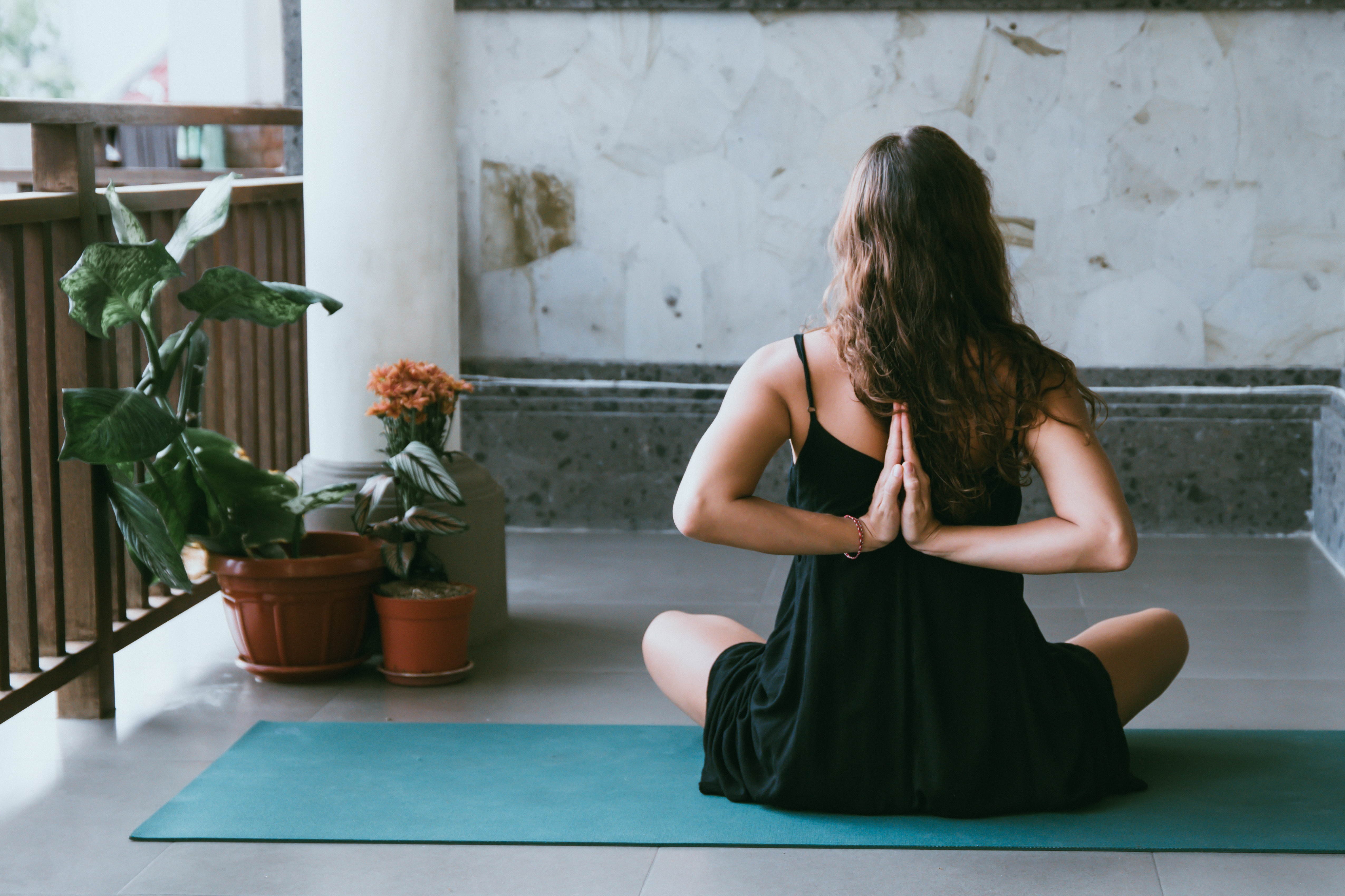Woman practicing yoga on a balcony with plants HD Wallpaper