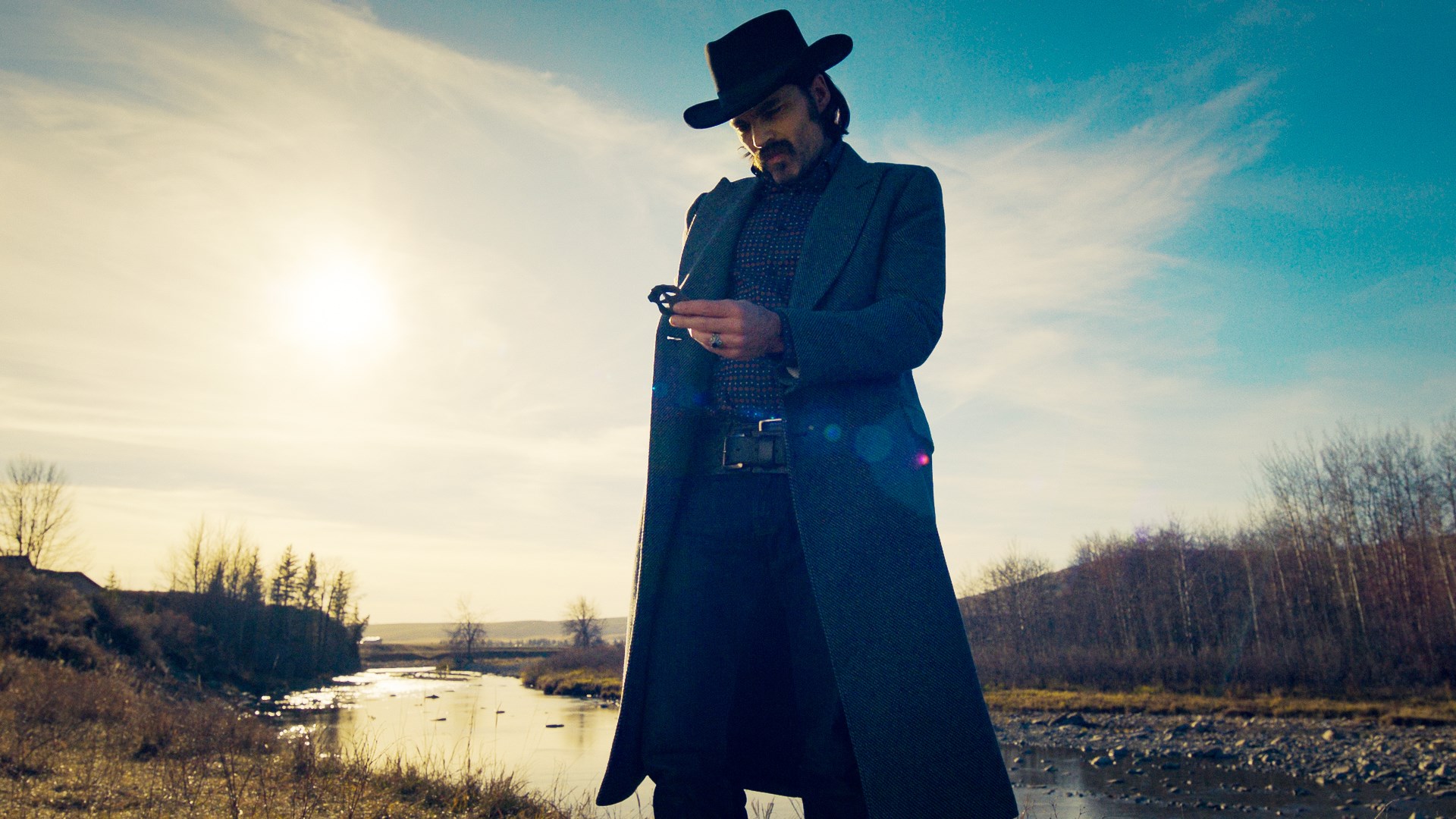 Man in cowboy hat and coat holding a ring HD Wallpaper