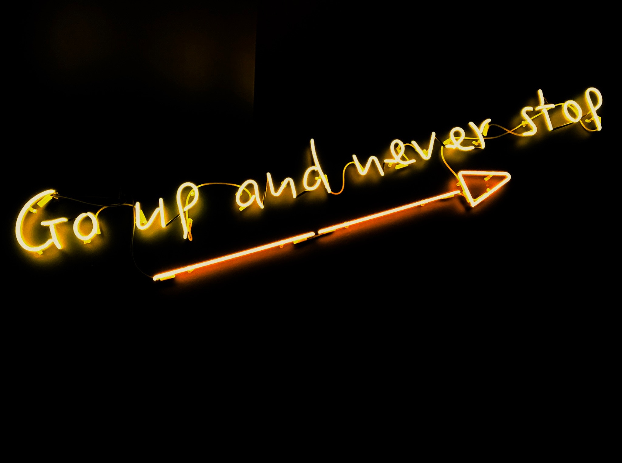 Neon sign 'Go up and never stop' with arrow HD Wallpaper