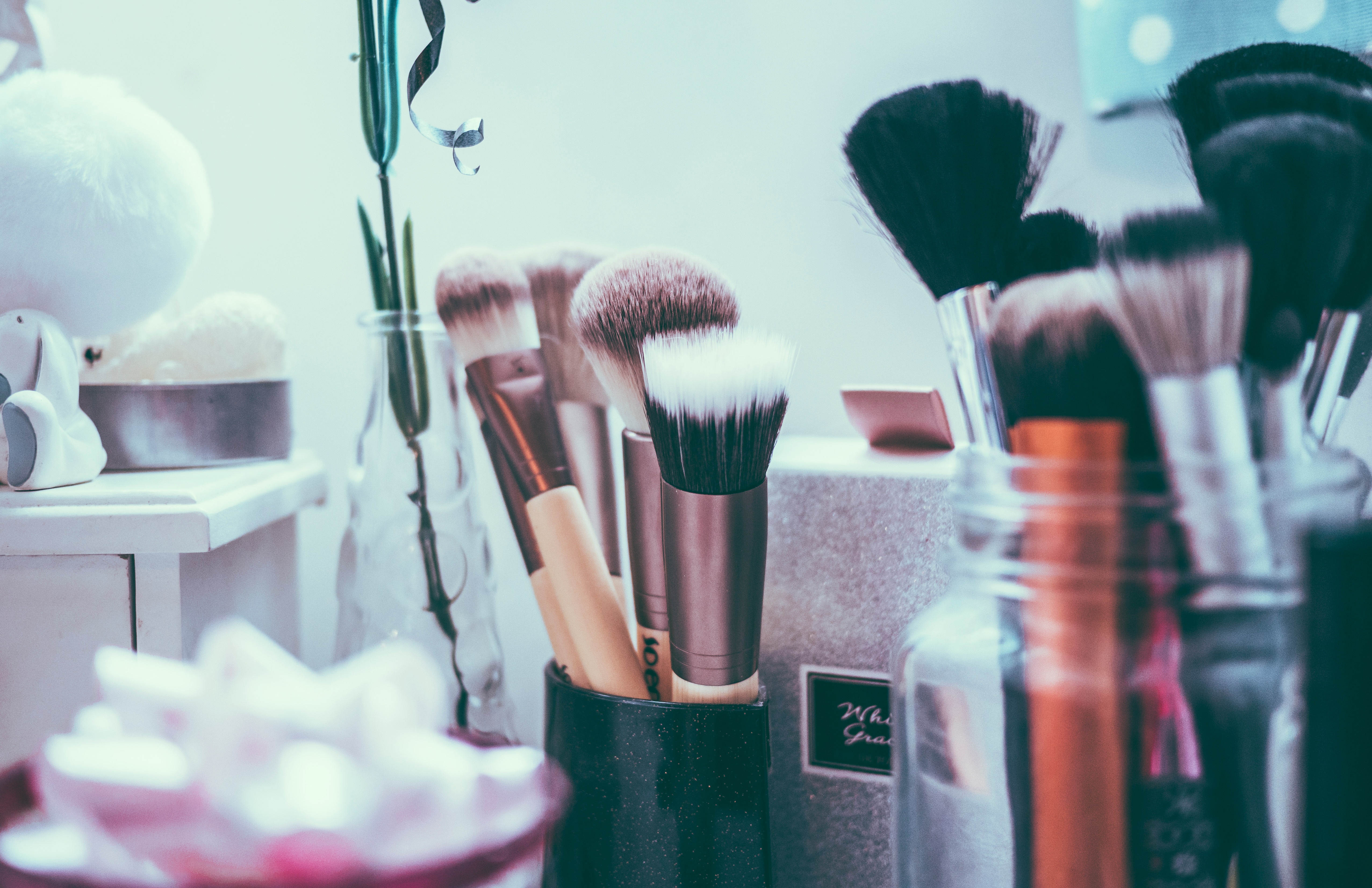 Makeup brushes in jars on a vanity HD Wallpaper