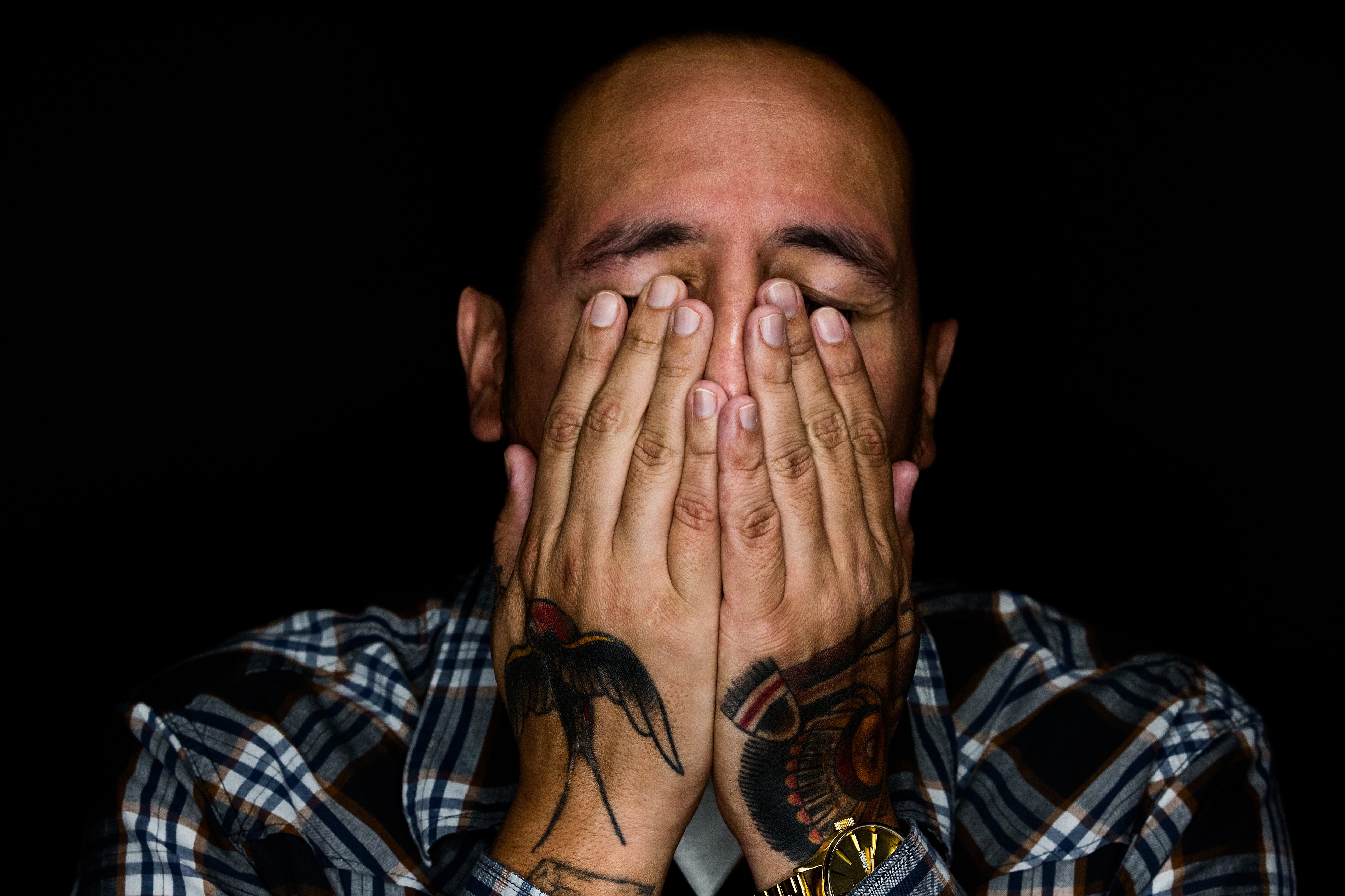 Man covering his face with tattooed hands HD Wallpaper