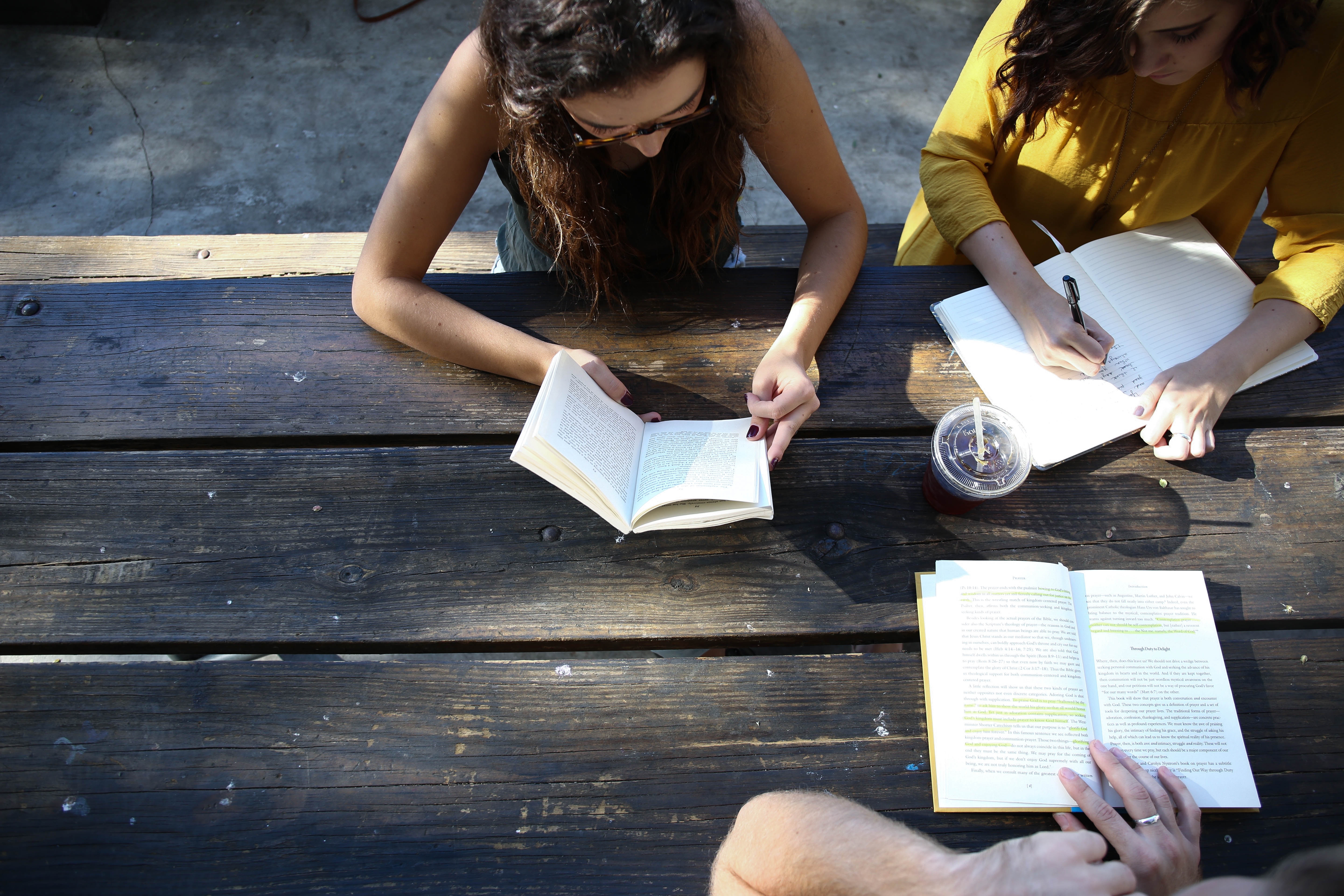 Women studying and reading at a wooden table HD Wallpaper