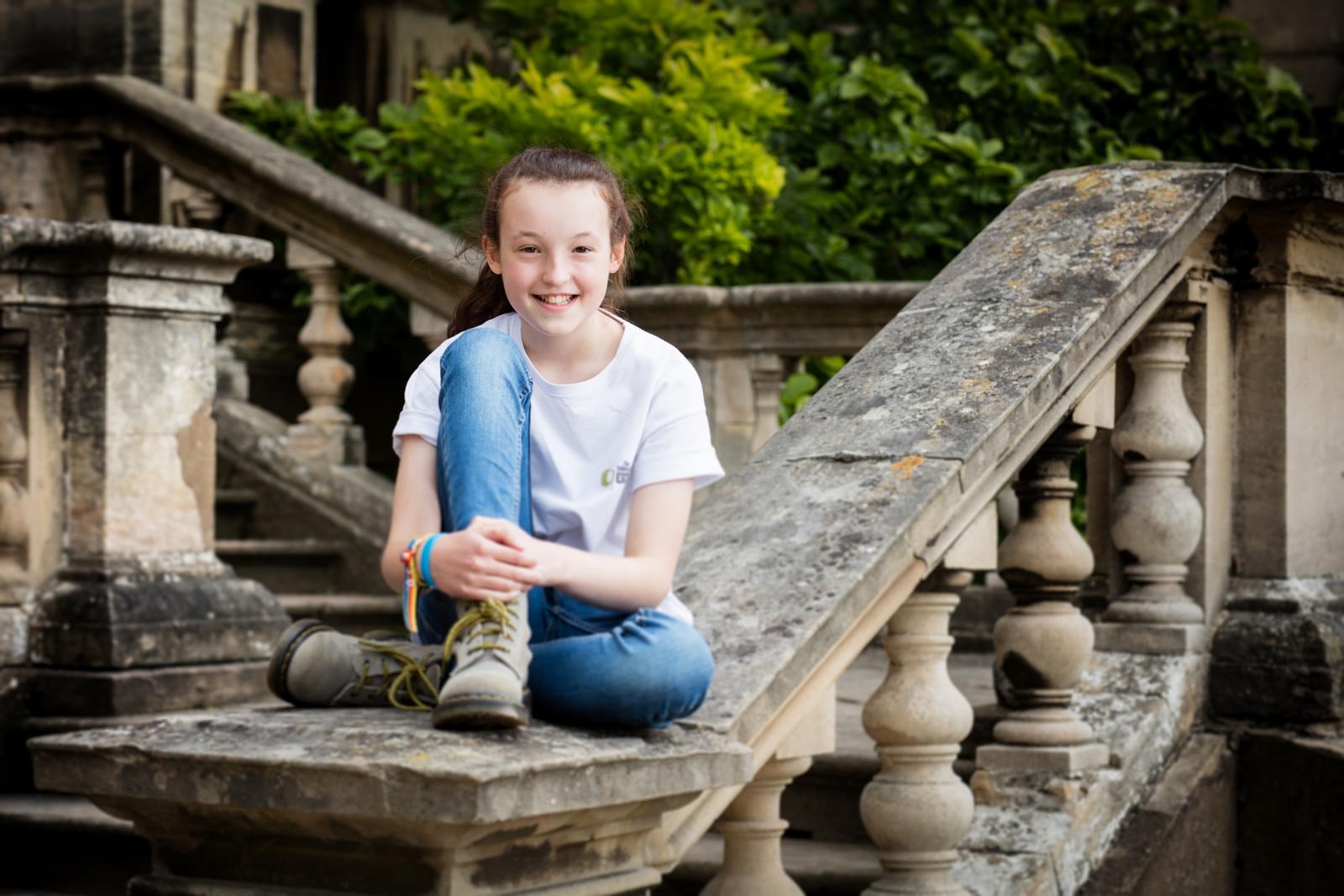 Bella Ramsey sitting on stone stairs HD Wallpaper