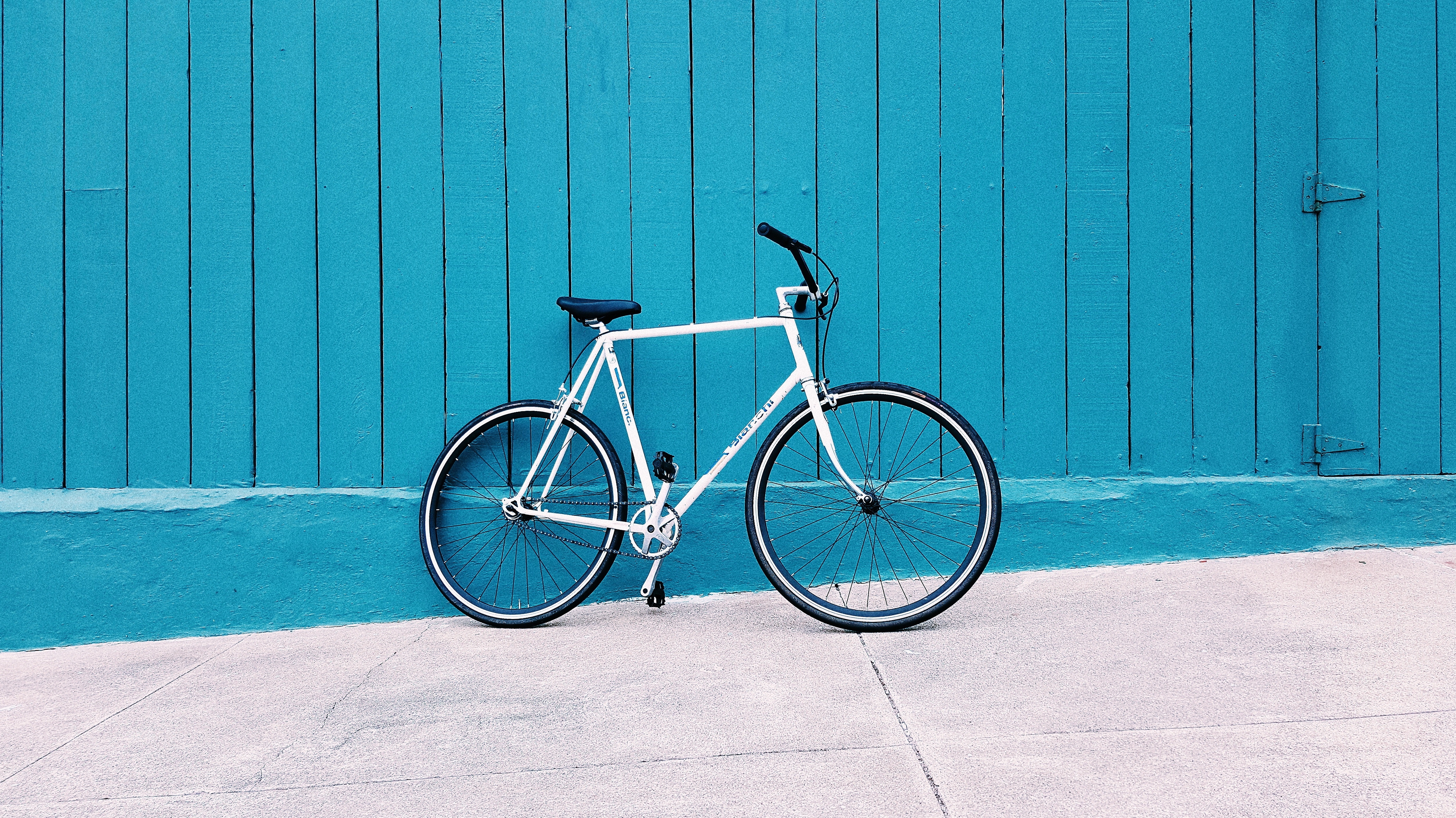 White Bianchi bicycle against a teal wooden wall HD Wallpaper