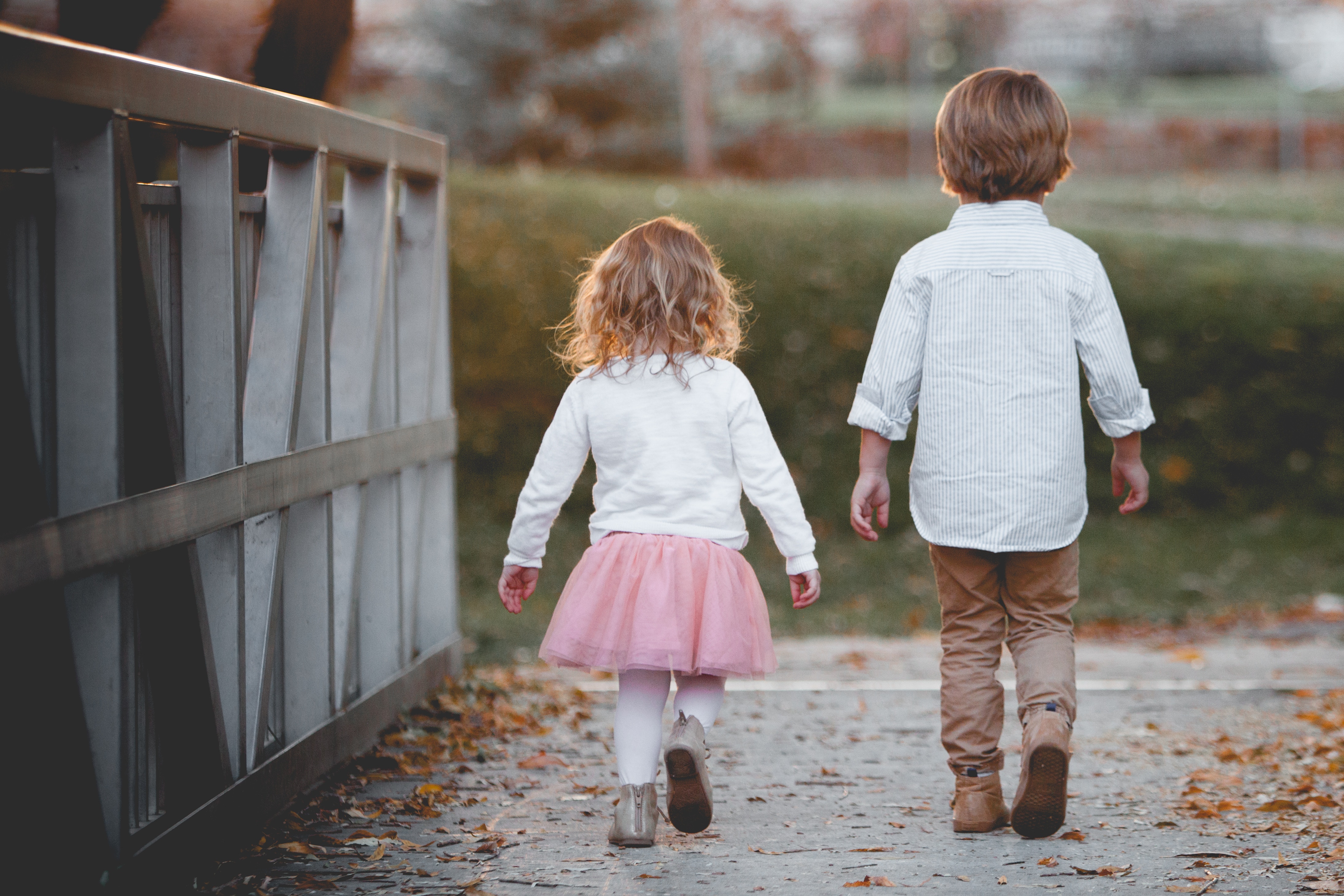 Brother and Sister Walking on Autumn Path HD Wallpaper