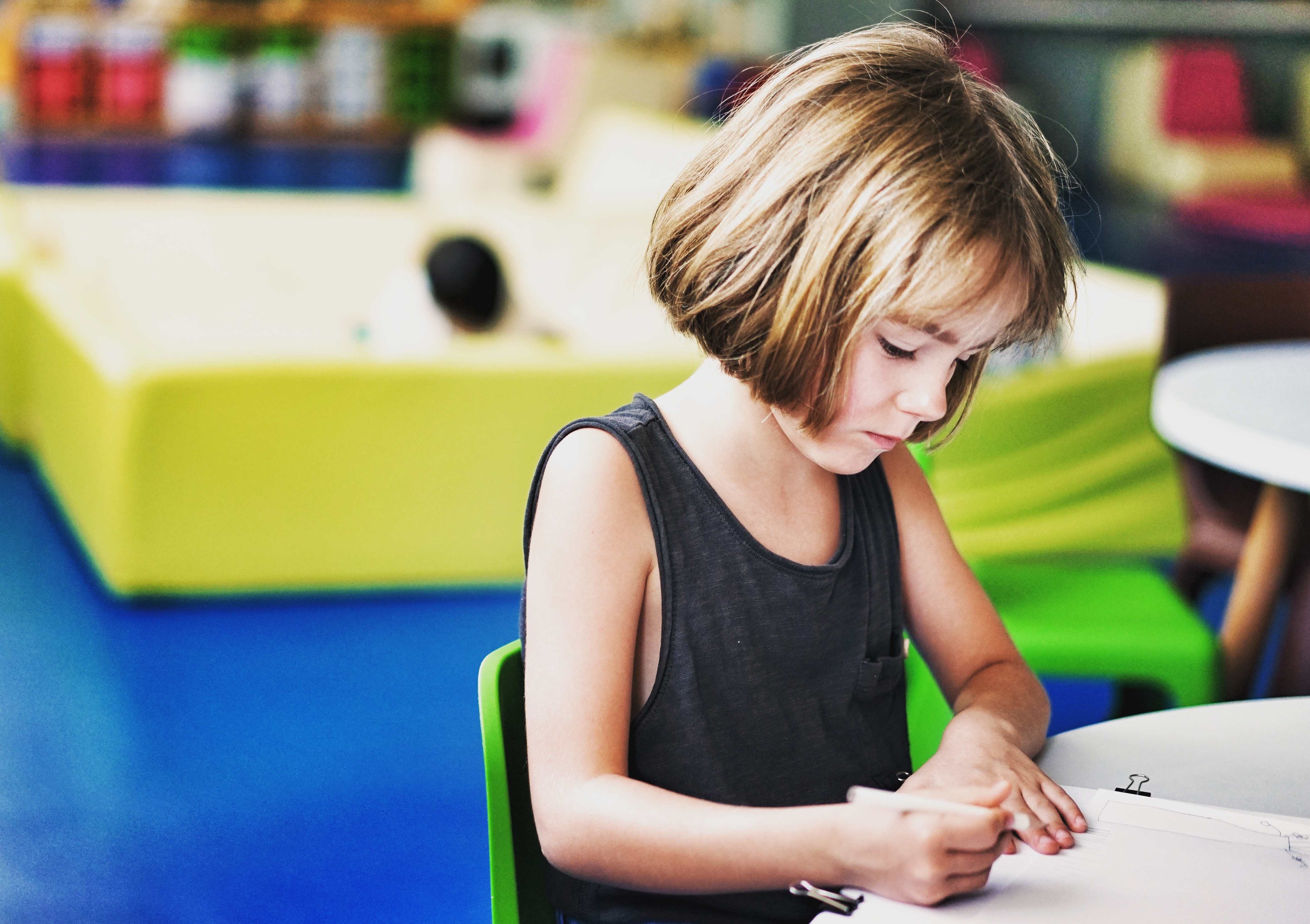 Child learning and writing at a desk HD Wallpaper