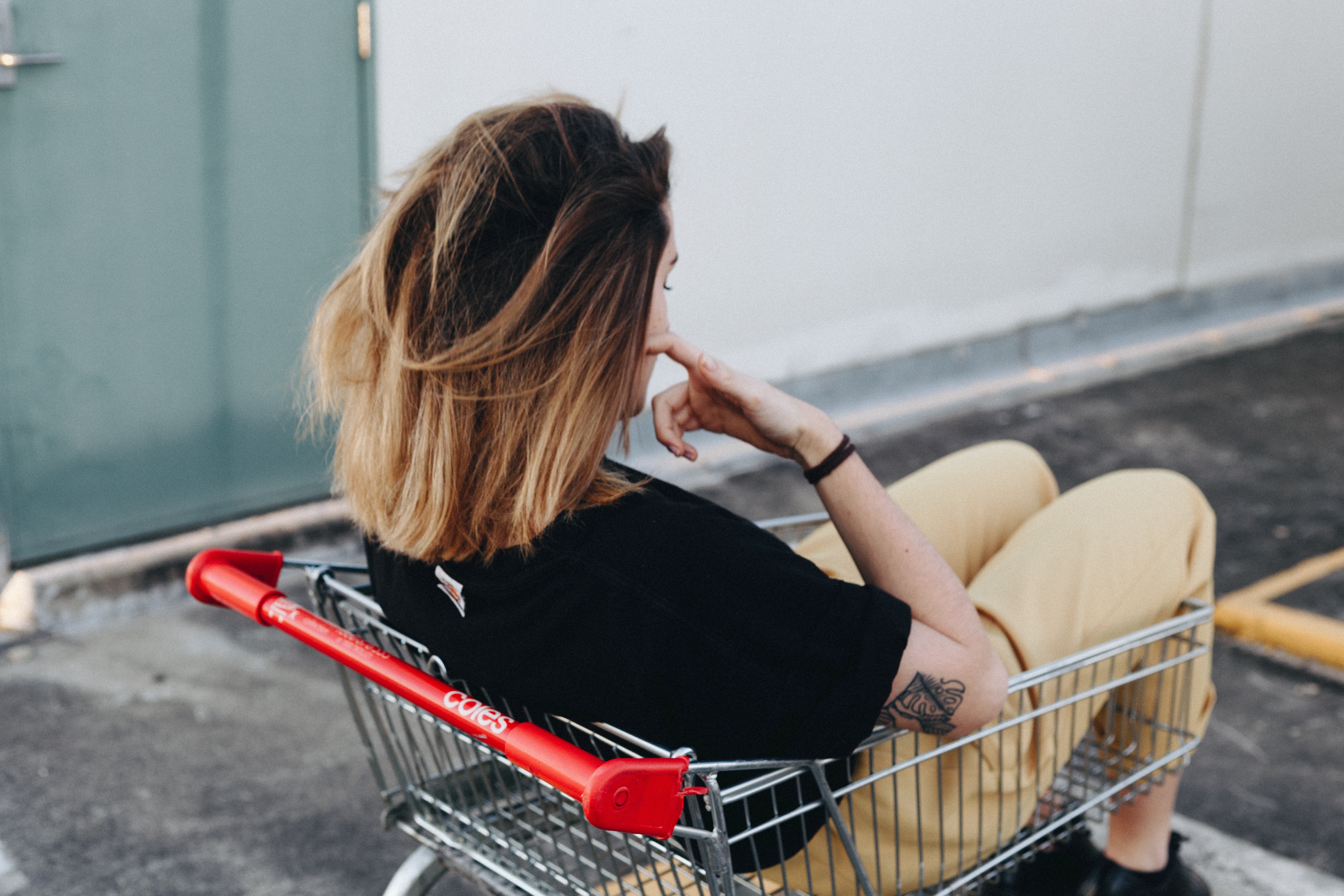 Woman sitting in a shopping cart HD Wallpaper