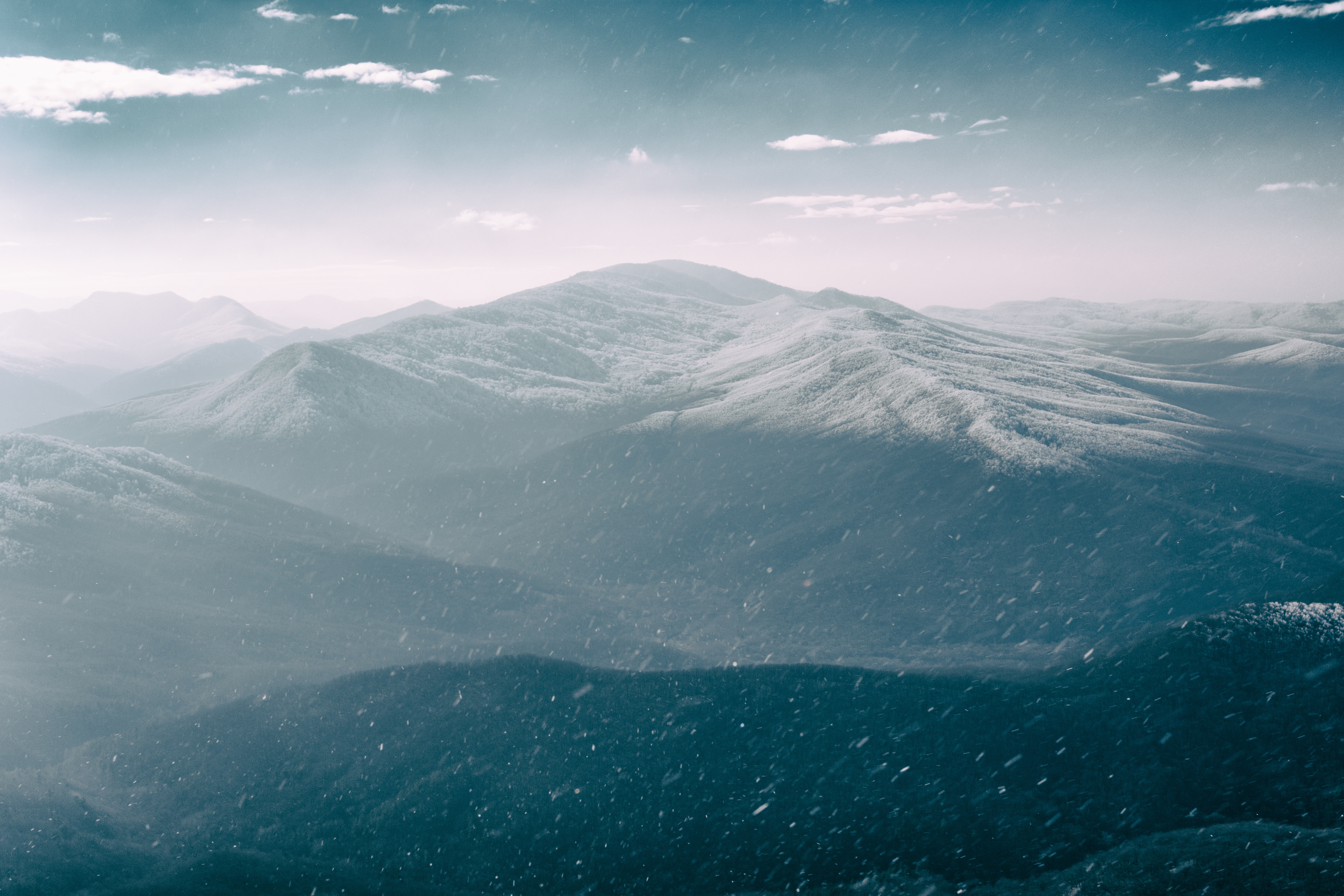 Snowy mountain range under a cloudy sky HD Wallpaper