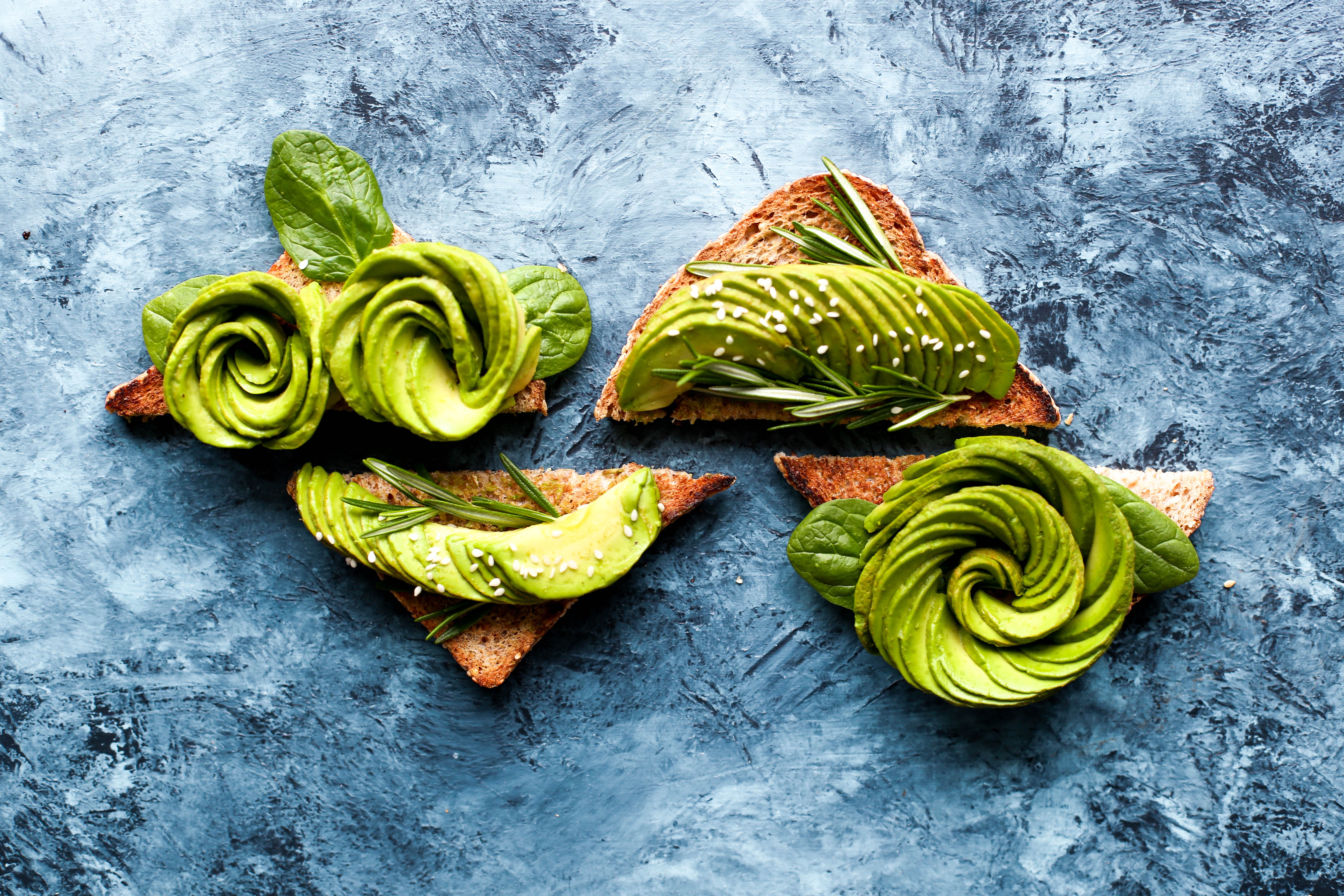 Avocado toast with spinach and rosemary on a blue textured background HD Wallpaper