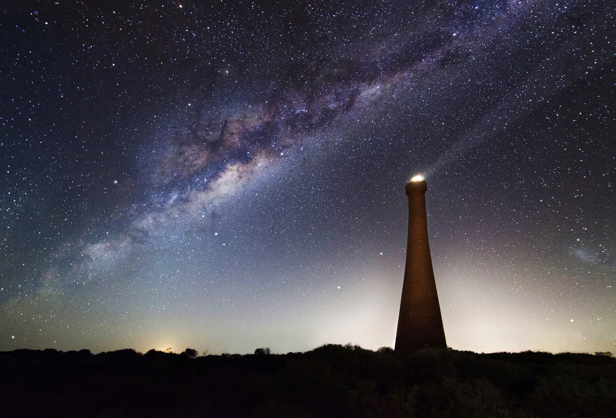Milky Way over a lighthouse at night HD Wallpaper