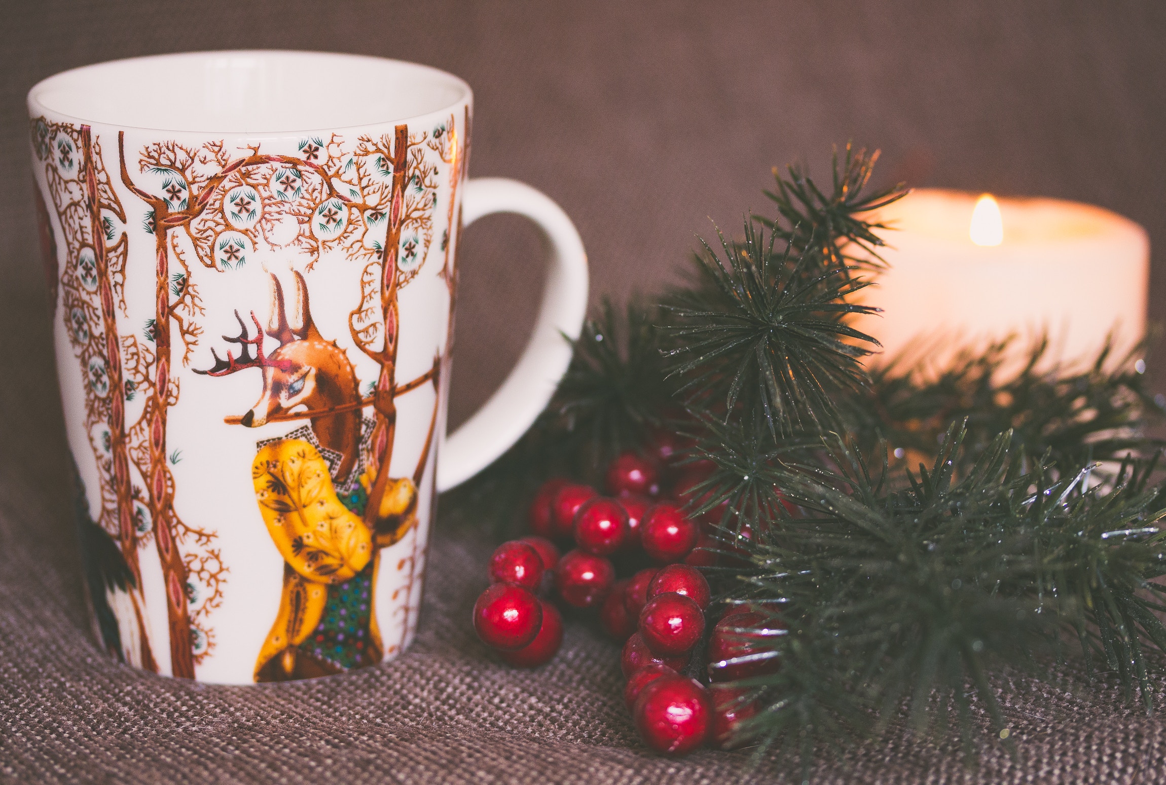 Christmas mug with deer, berries, and candle HD Wallpaper