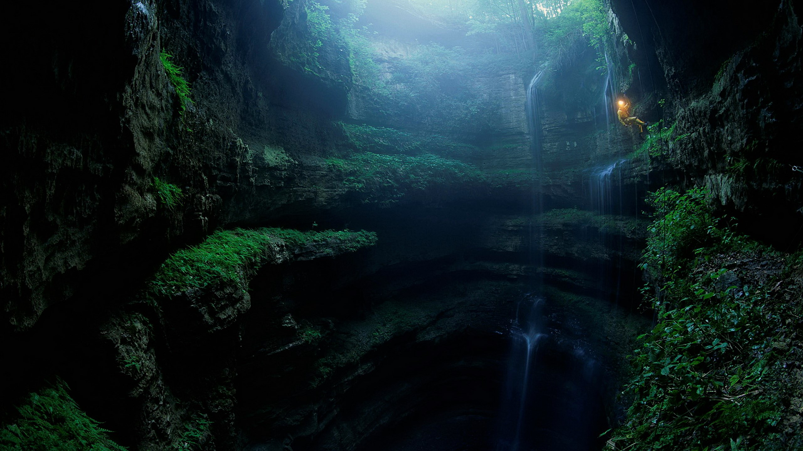 Cave explorer rappelling down a waterfall HD Wallpaper