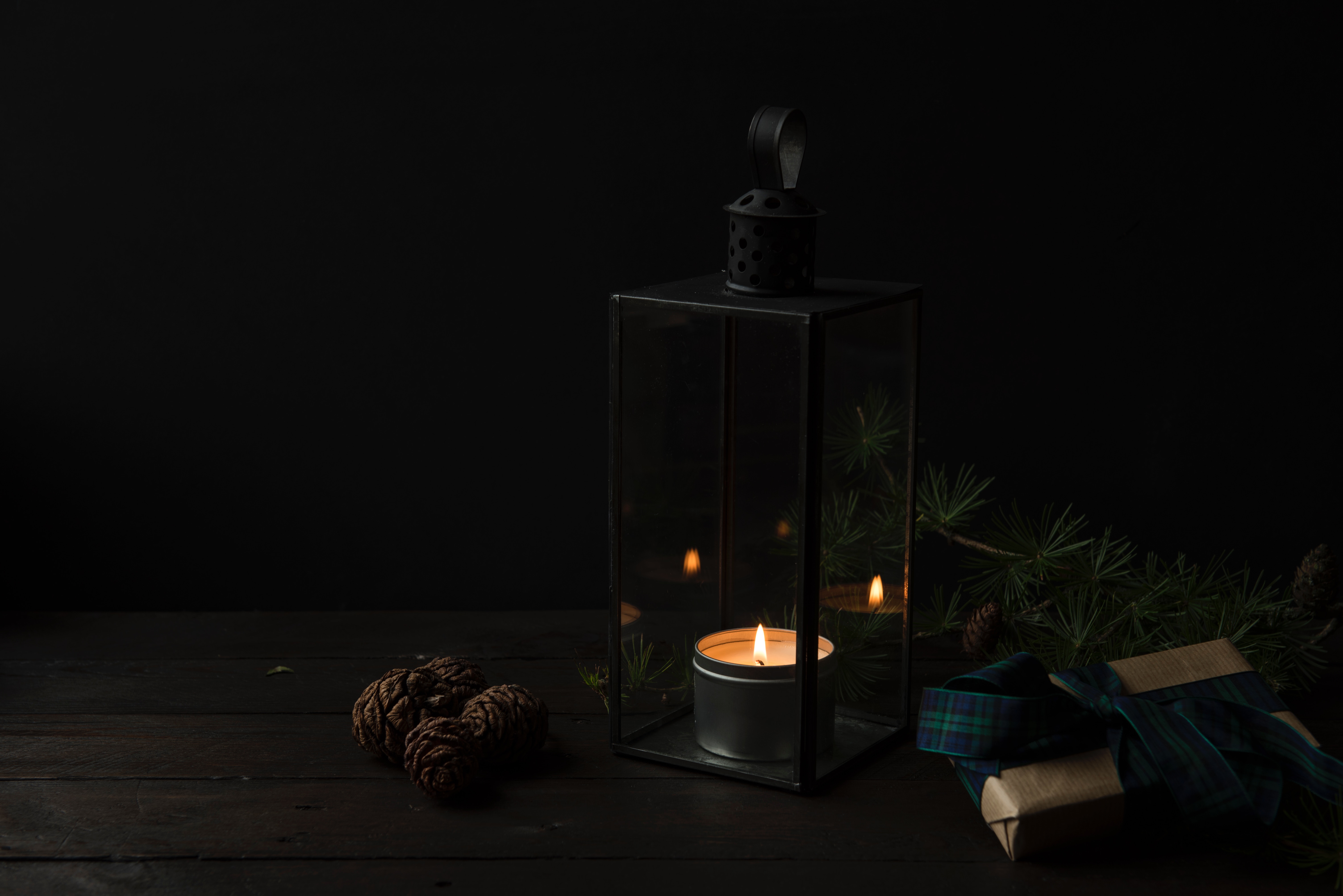 Festive Candle Lantern with Pine Cones and Gifts HD Wallpaper