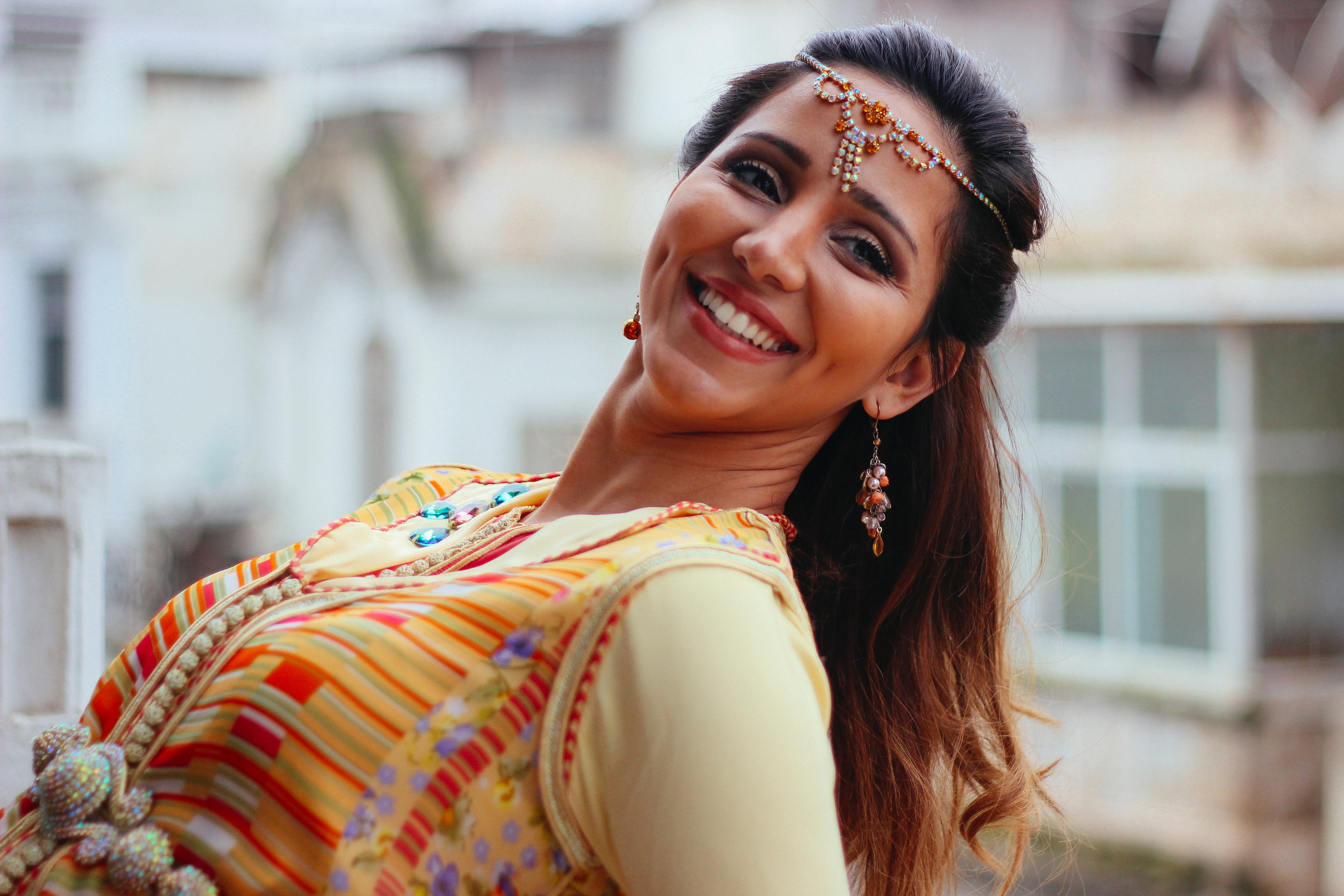 Woman in traditional dress with headdress smiling HD Wallpaper