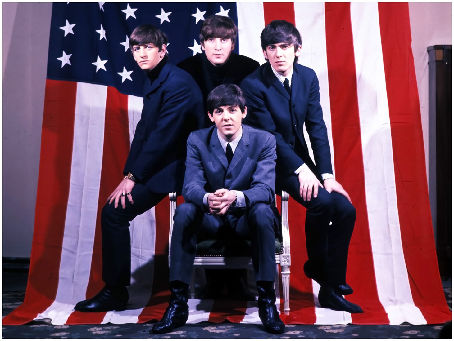 The Beatles posing in front of an American flag HD Wallpaper