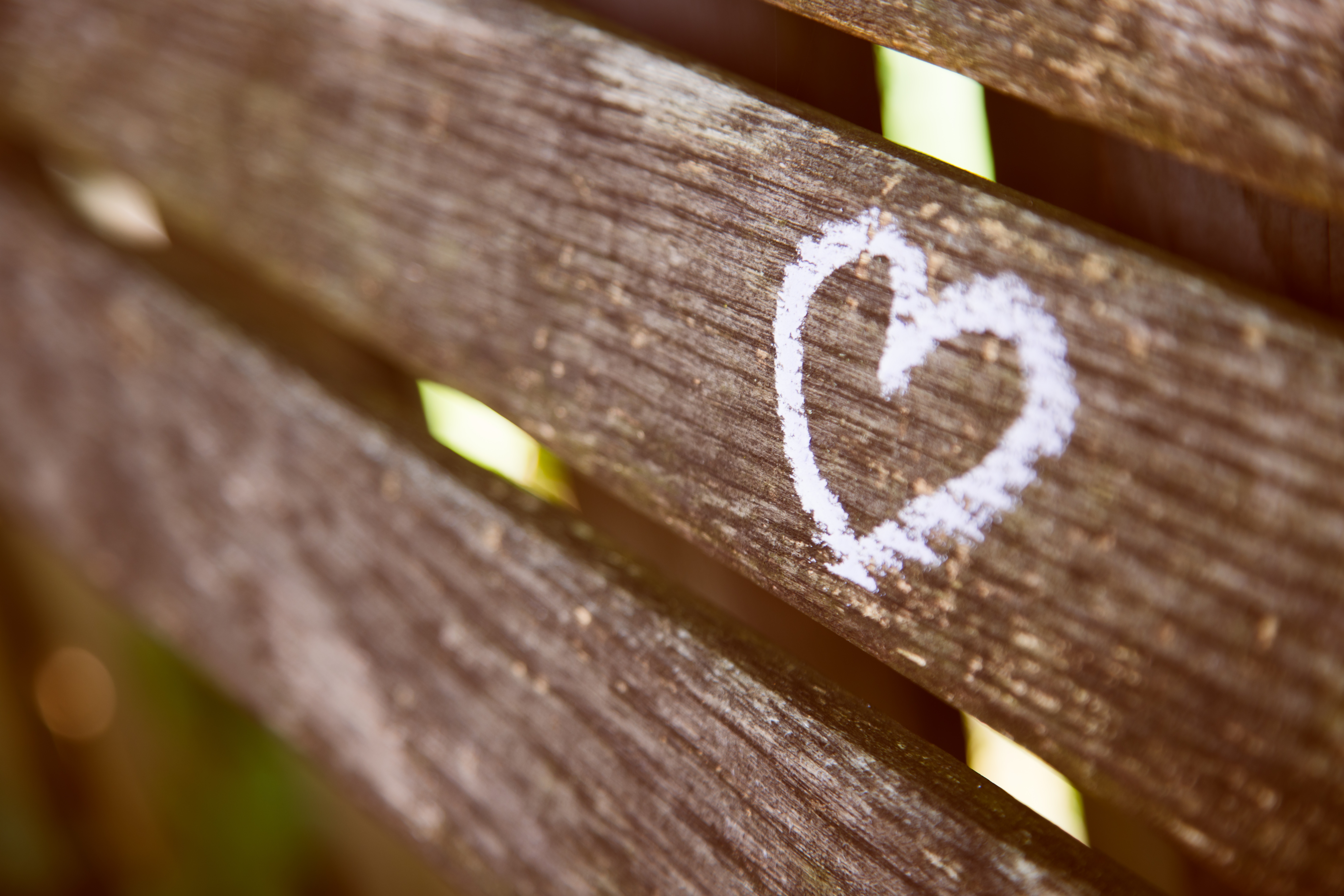 White heart drawn with chalk on a wooden bench HD Wallpaper