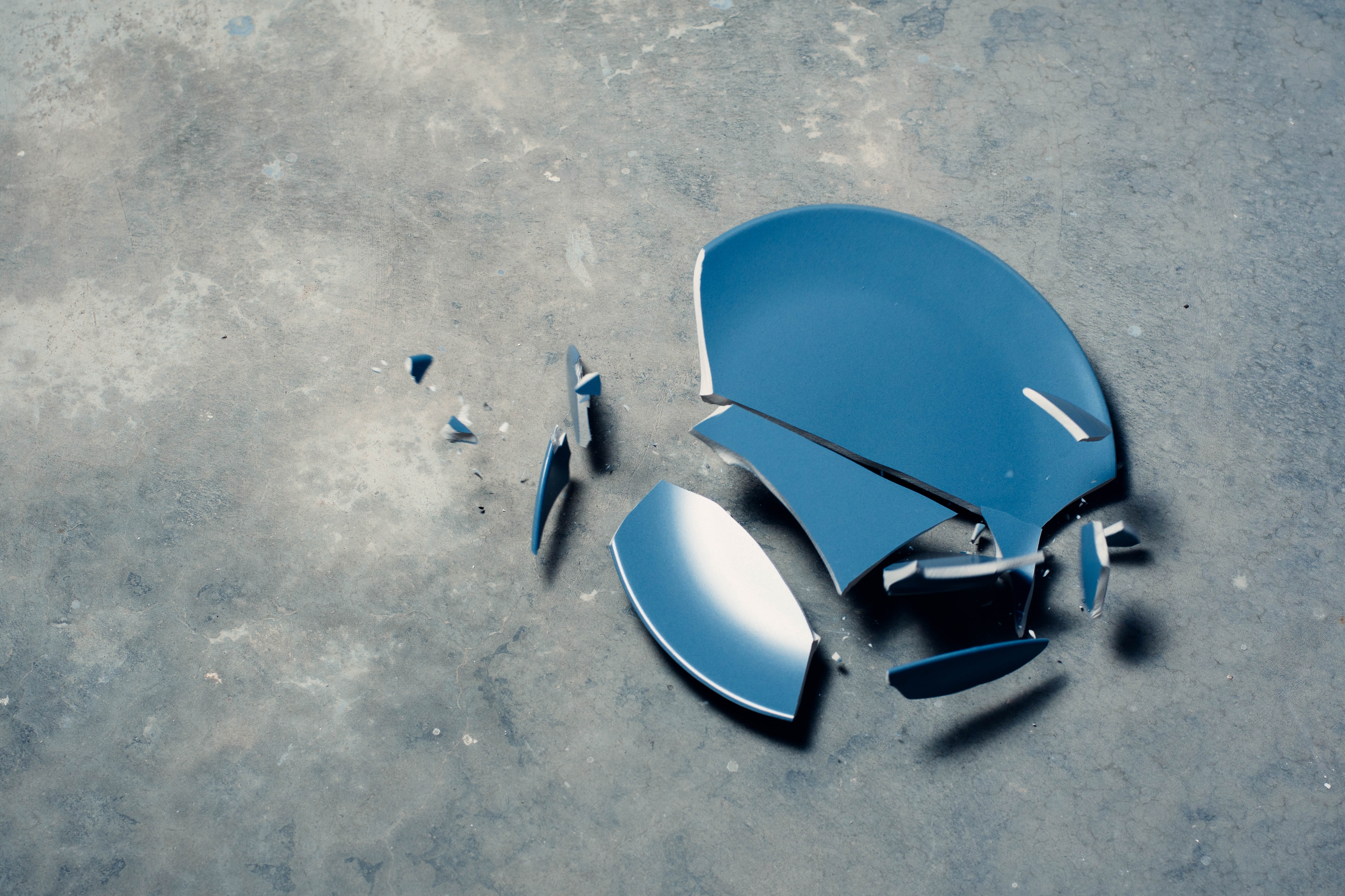 Broken blue plate on a concrete floor HD Wallpaper