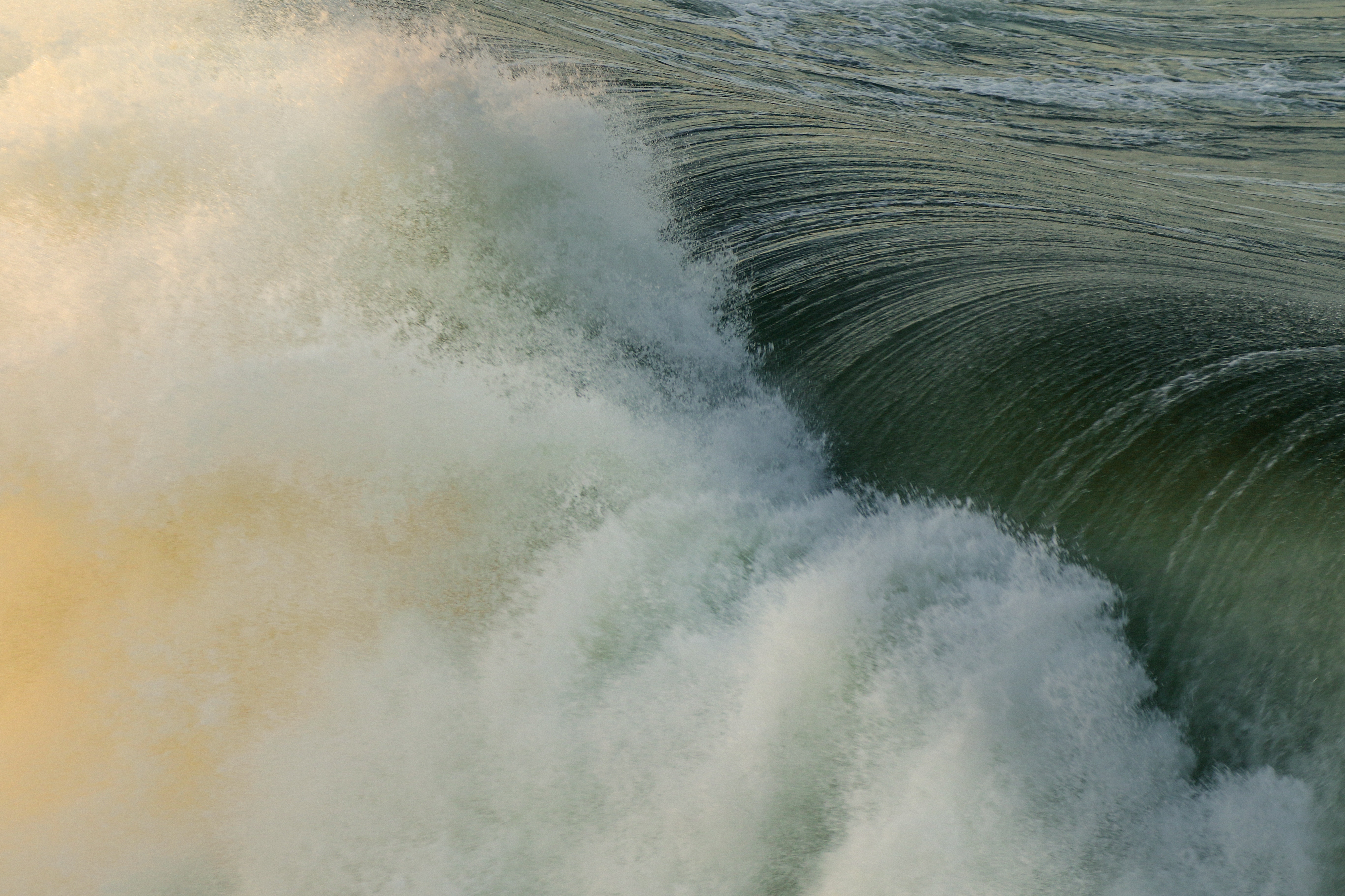 Close-up of a rough ocean wave with foam and sunlight HD Wallpaper