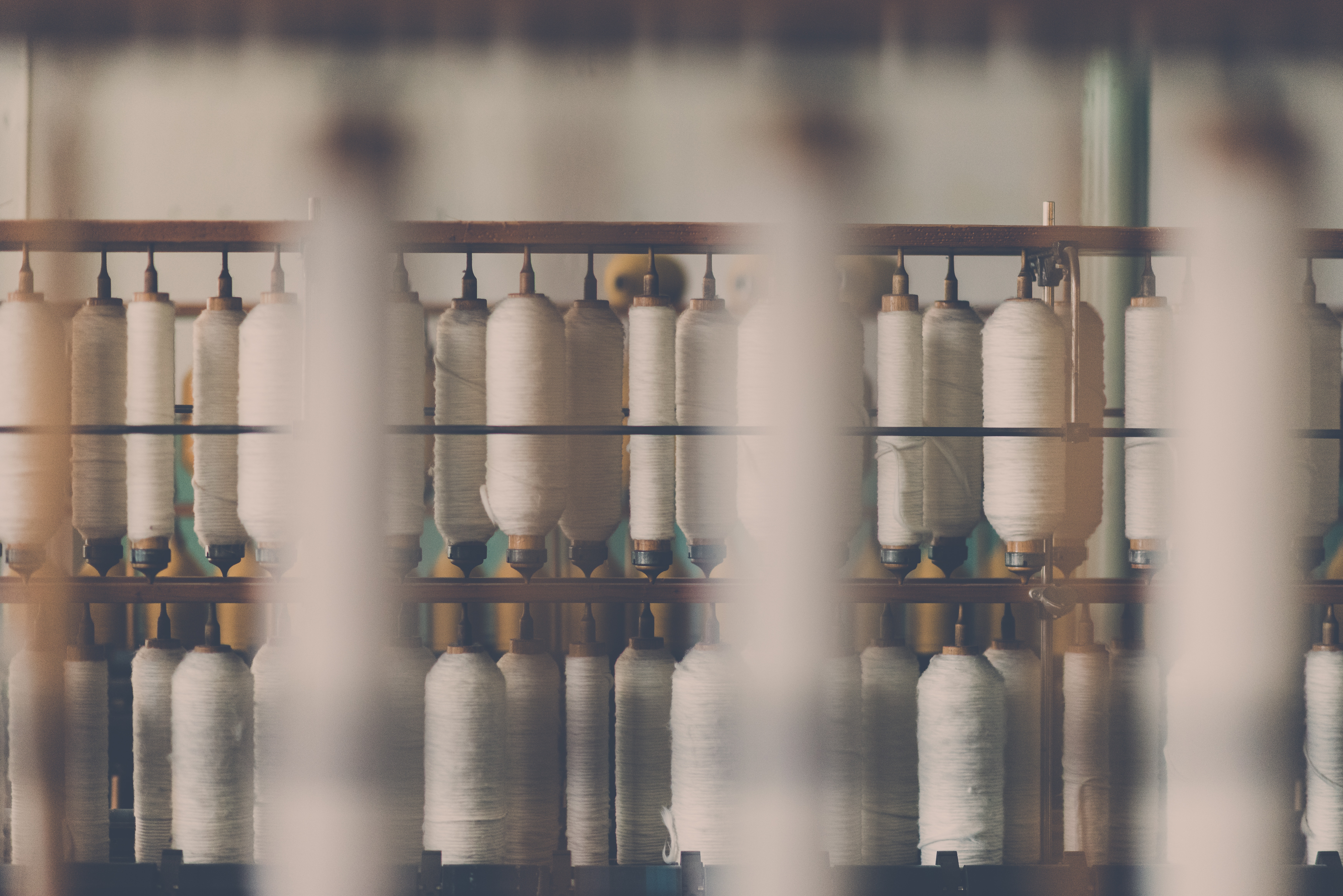 White spools of thread on a textile machine HD Wallpaper