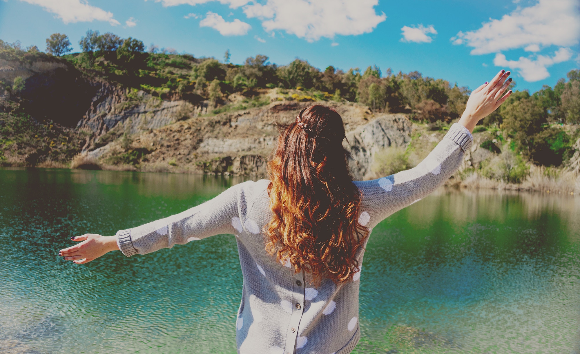 Woman with arms outstretched by a lake in Villanueva del Río y Minas HD Wallpaper