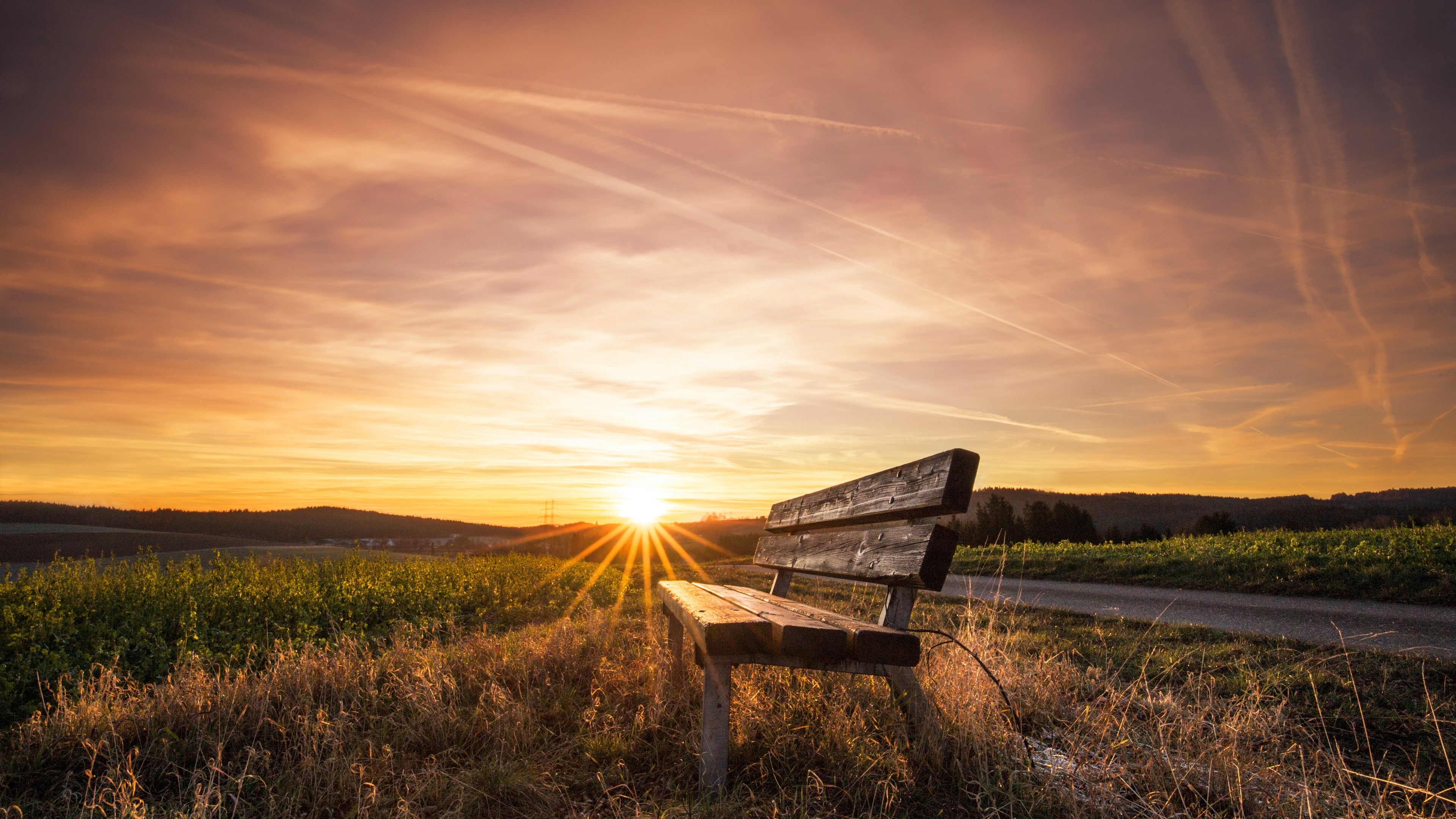 Wooden bench at sunset in a field HD Wallpaper