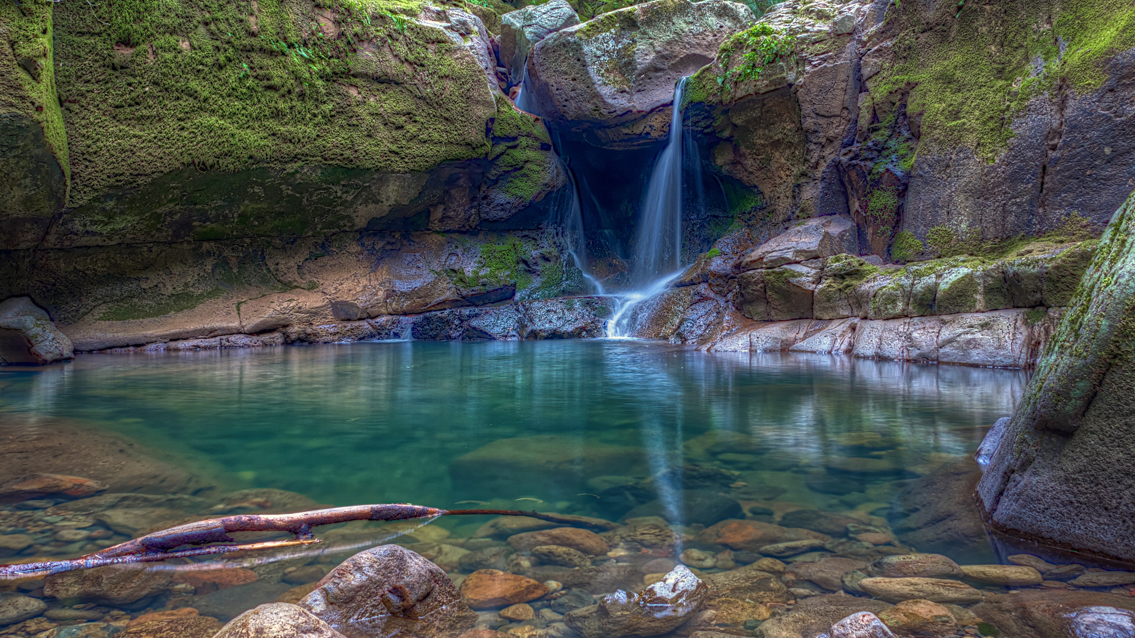 Waterfall cascading into a clear pool HD Wallpaper