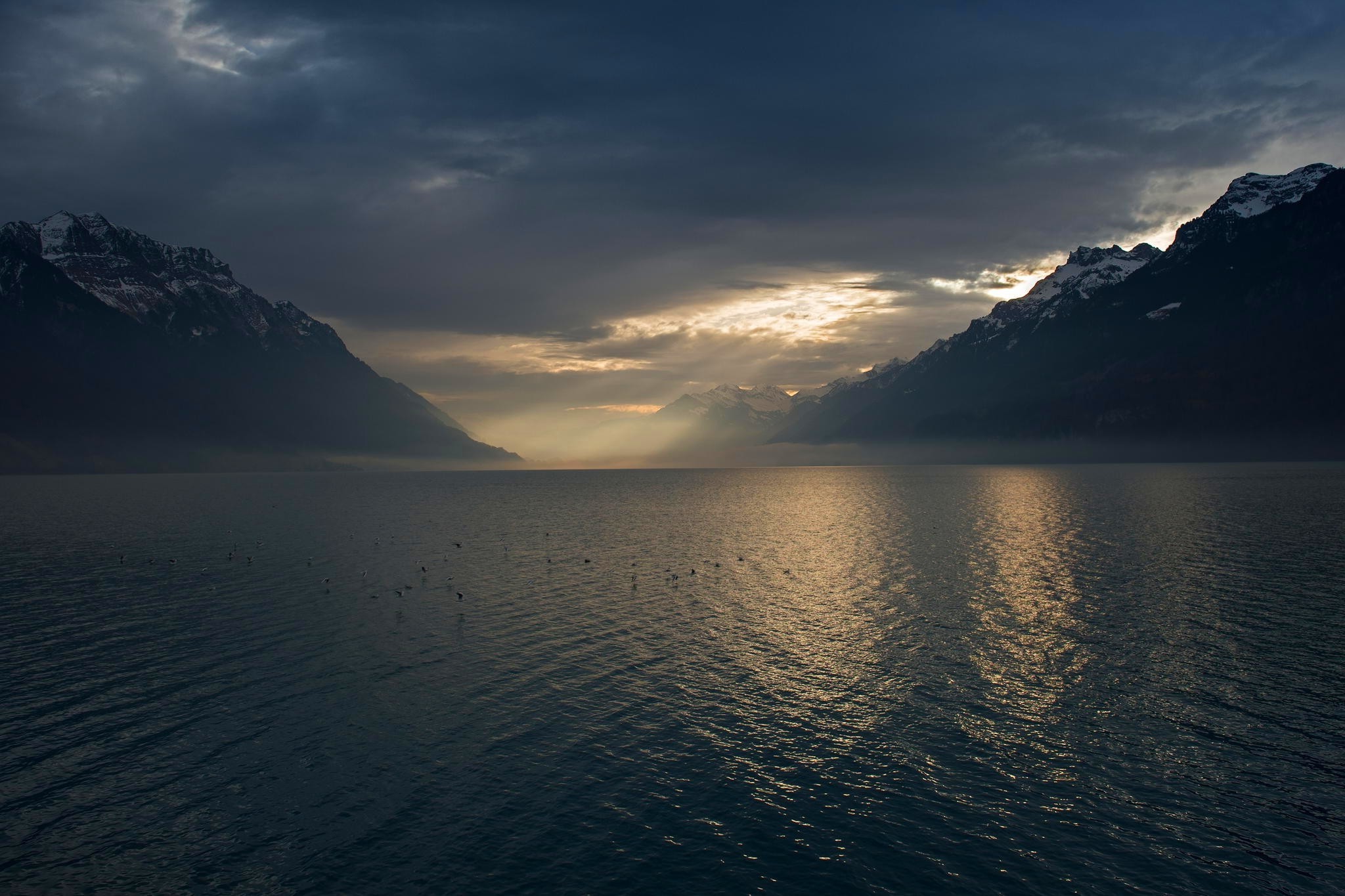 Sun rays through clouds over a lake and mountains HD Wallpaper